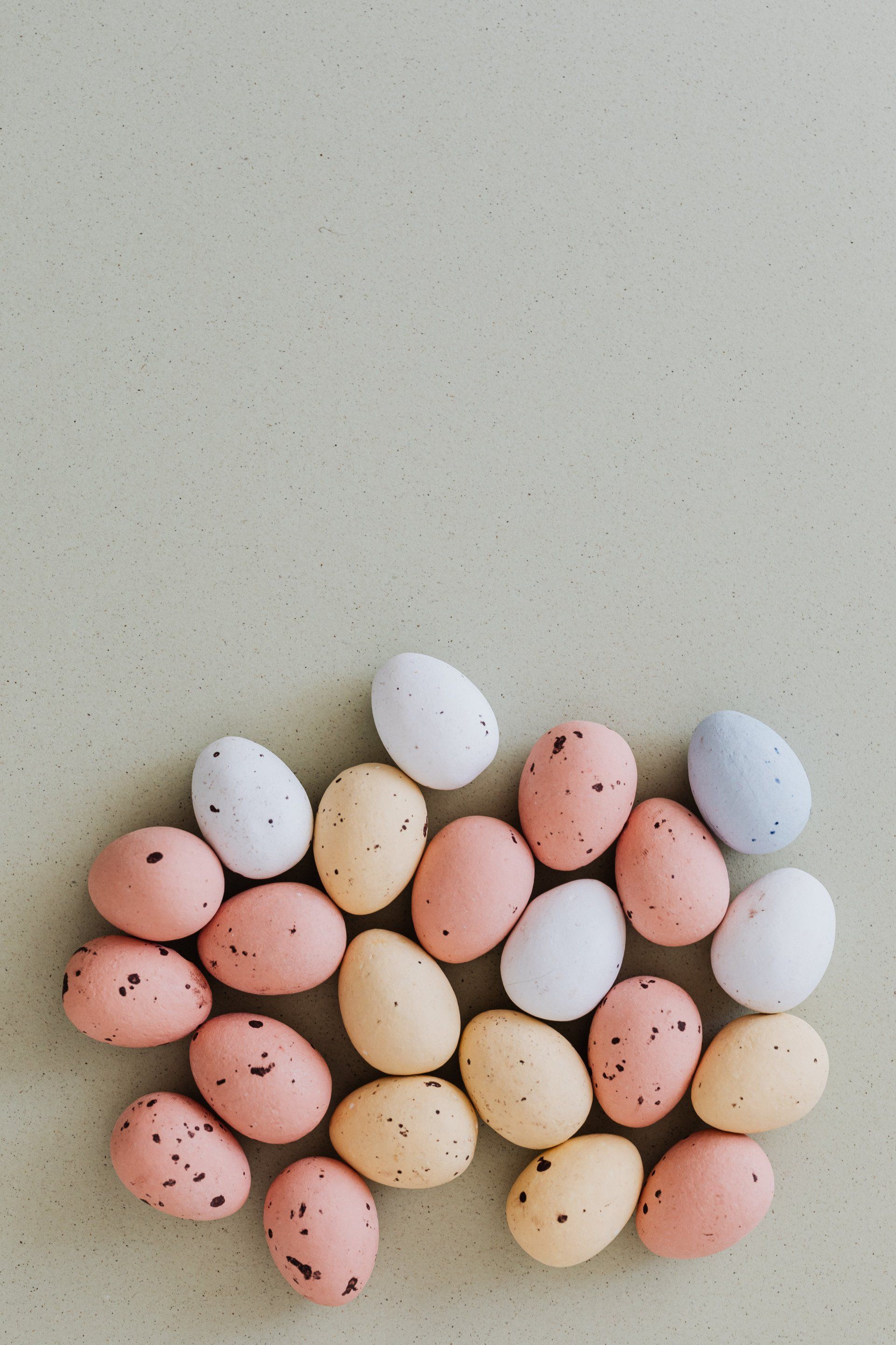 A bunch of easter eggs are sitting on top of each other on a table.