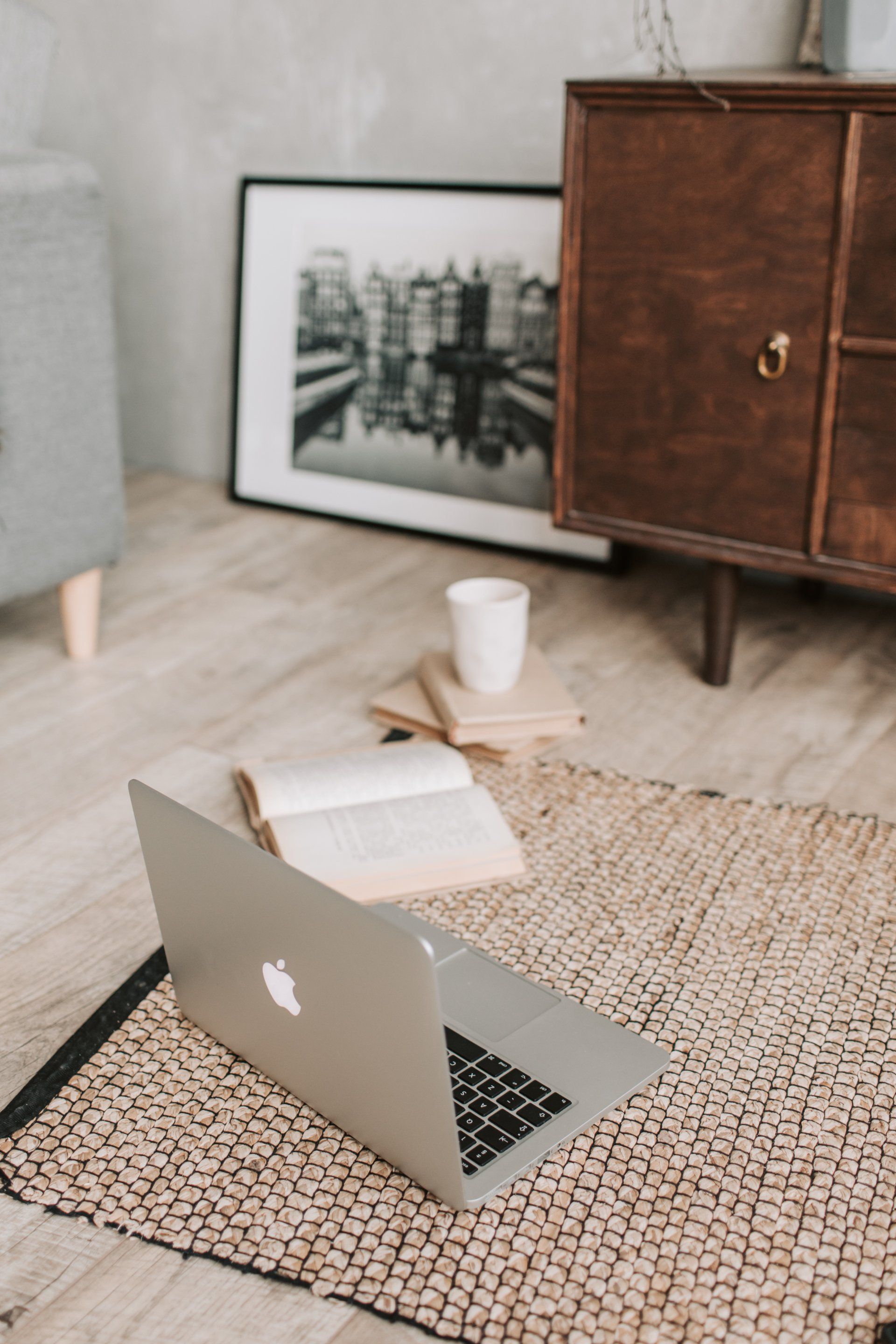 laptop and book on a carpet