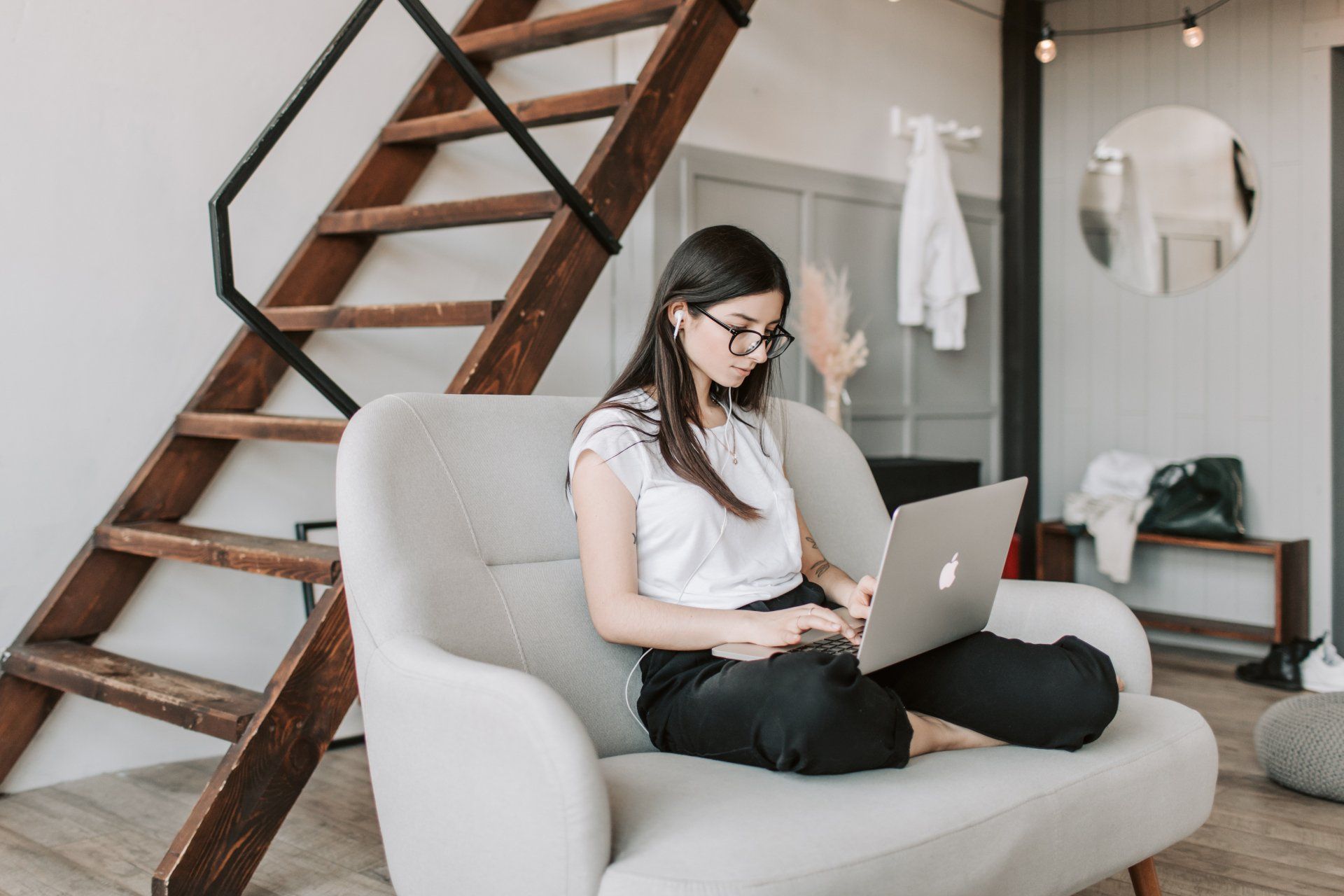 A woman is sitting in a chair using a laptop computer.