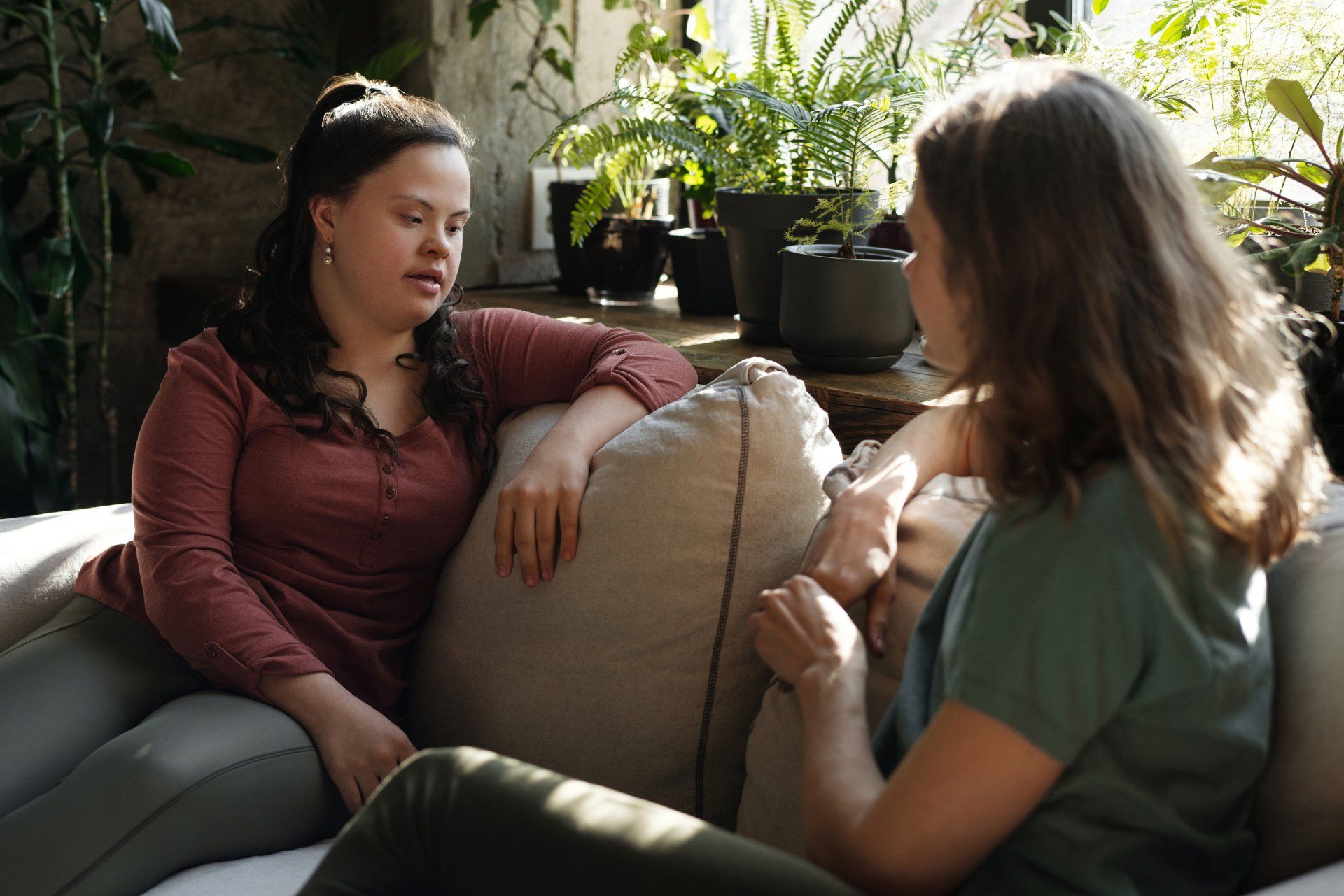 Zwei junge Frauen unterhalten sich auf dem Sofa