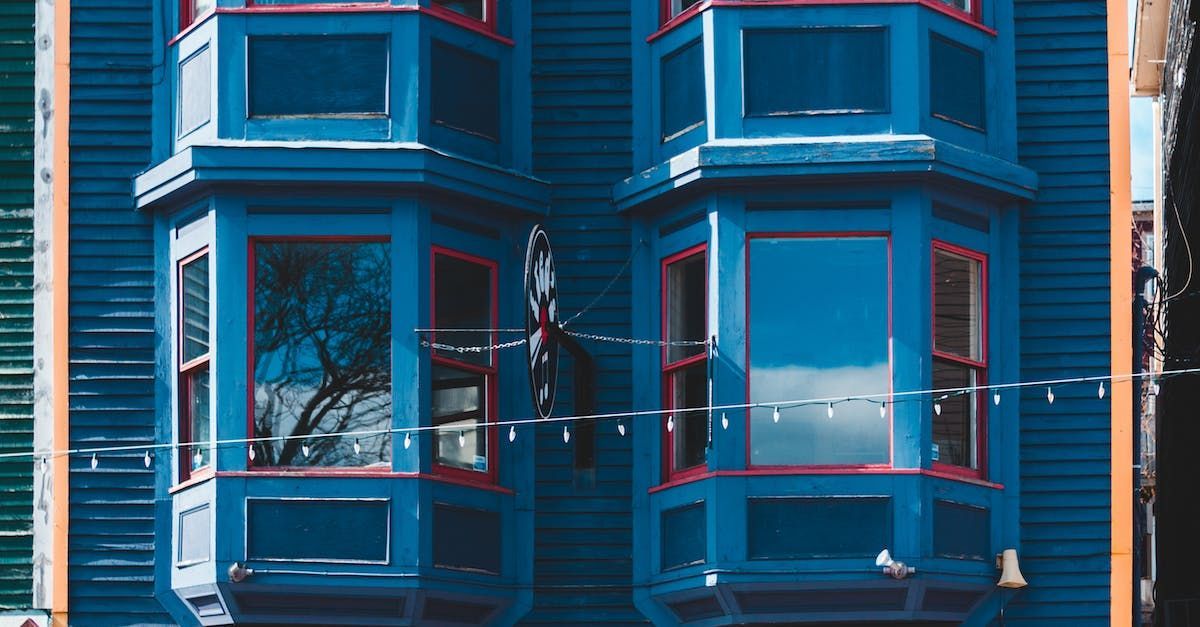 A blue building with red trim and bay windows.