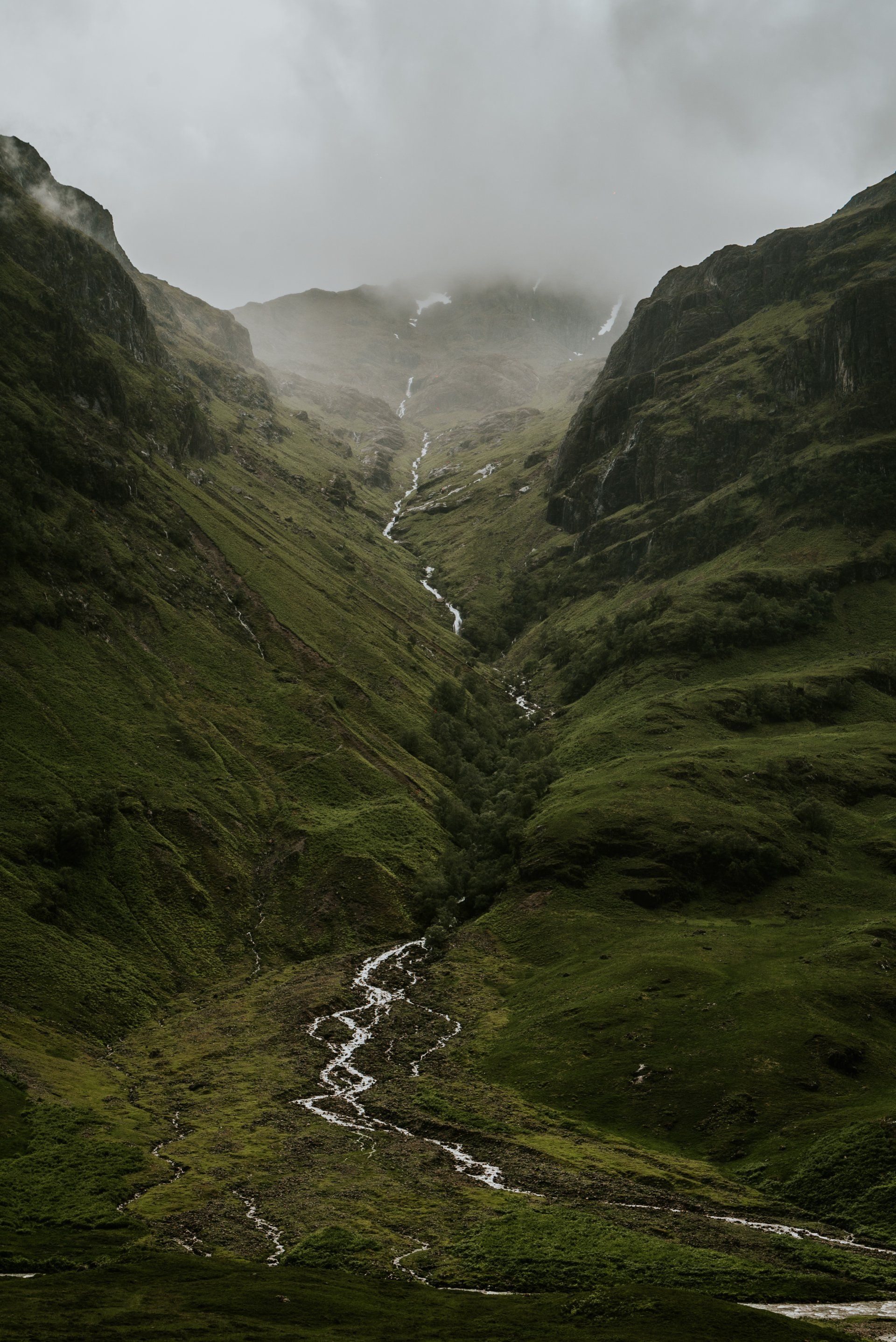 A river runs through a valley between two mountains in Scotland.