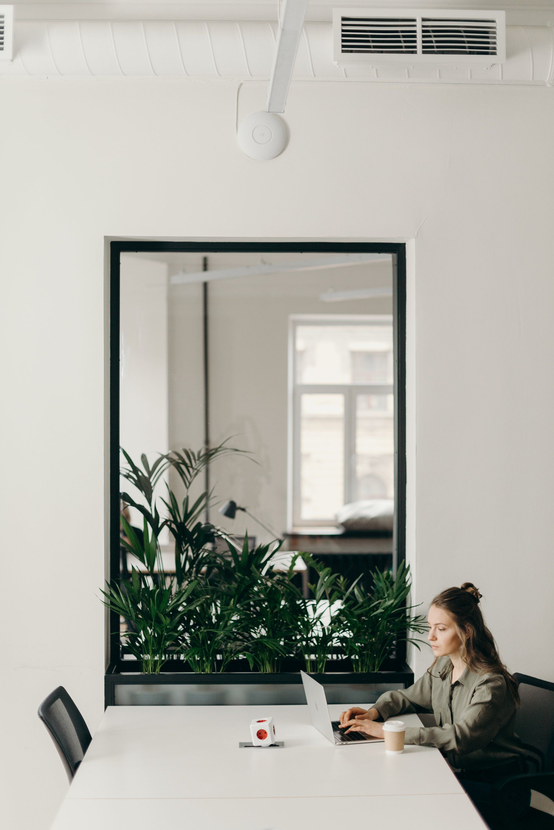 A woman is sitting at a table using a laptop computer.