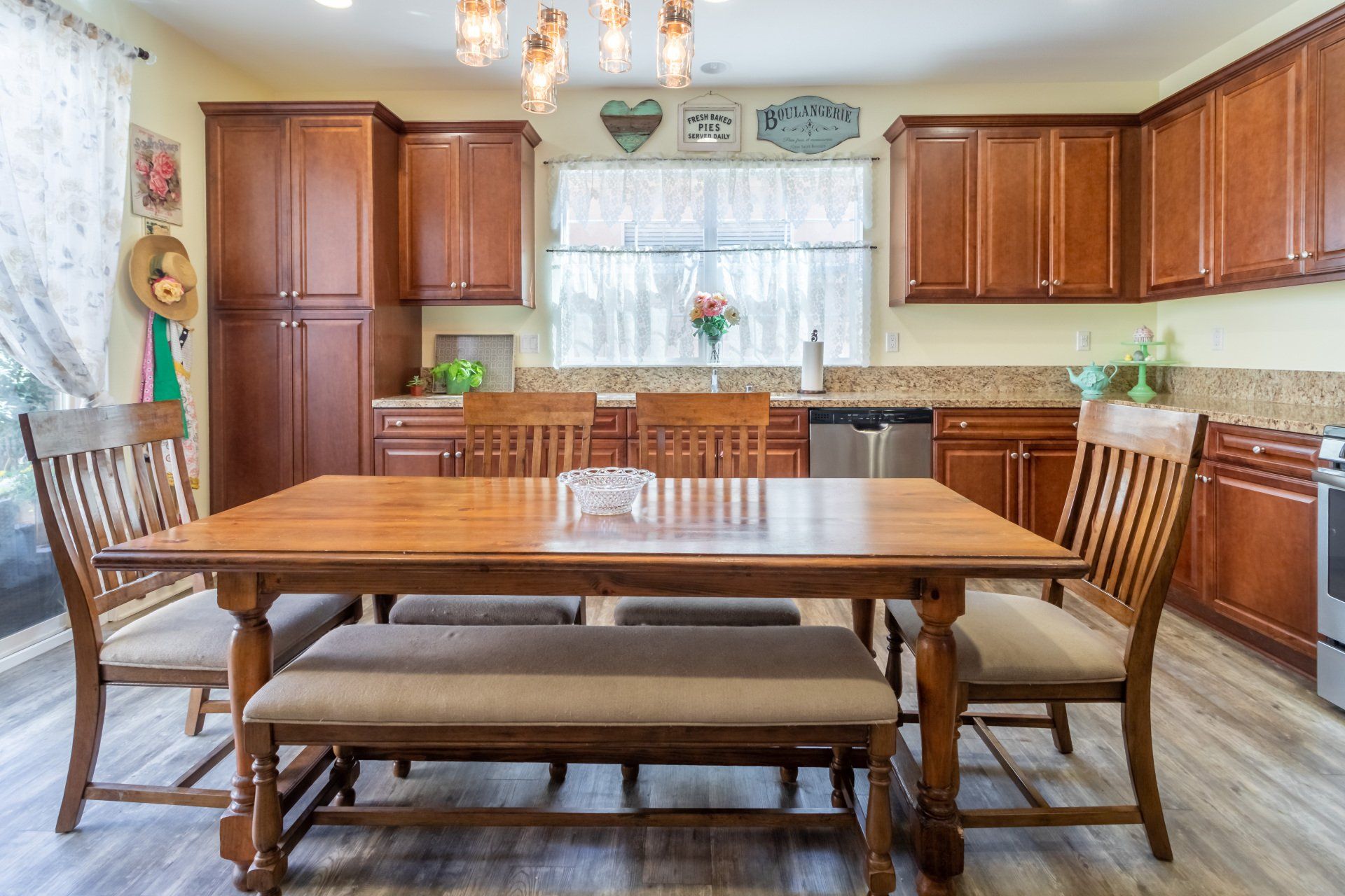 A kitchen with a wooden table and chairs and a bench.