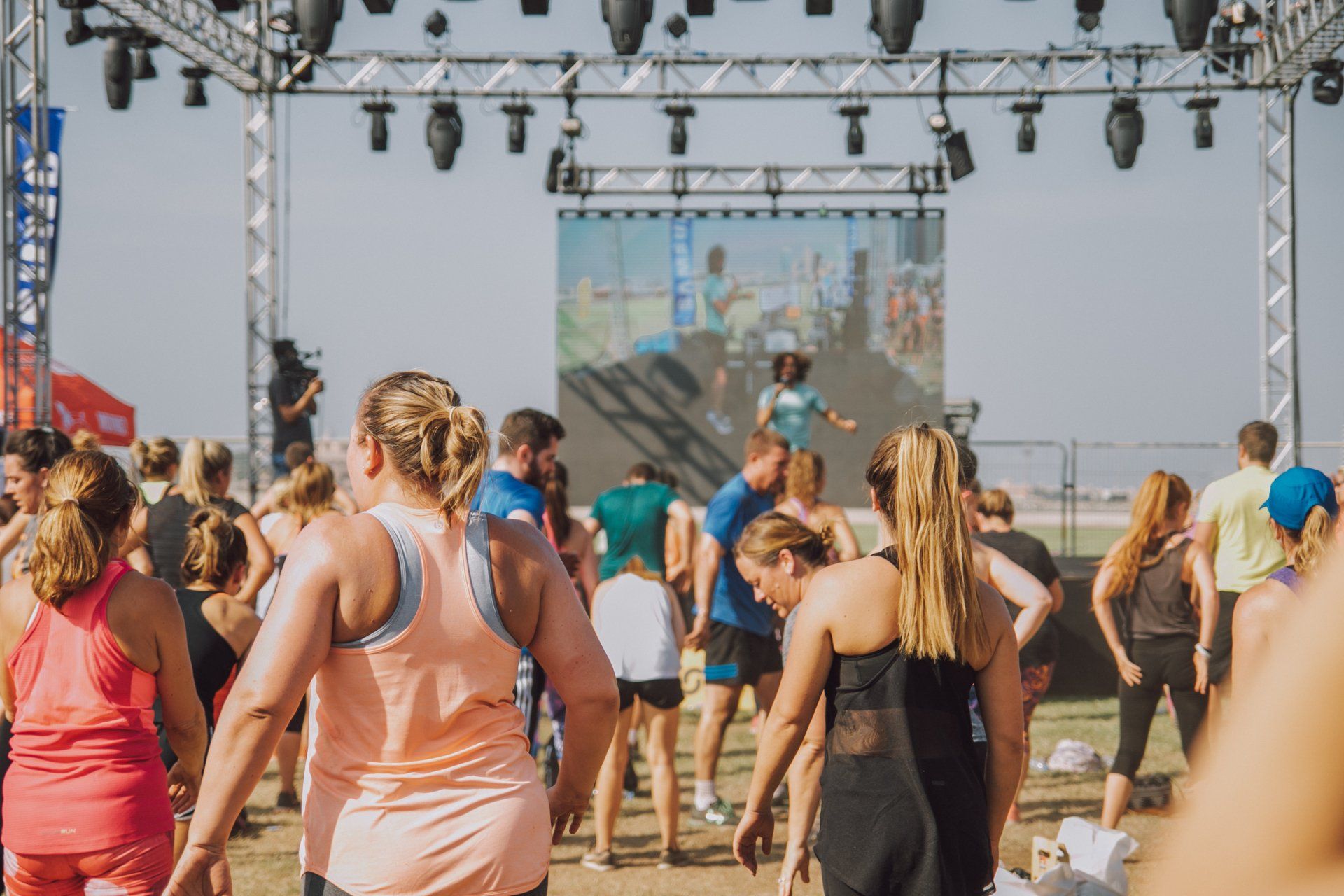 Un groupe de personnes danse devant une scène lors d'un festival.