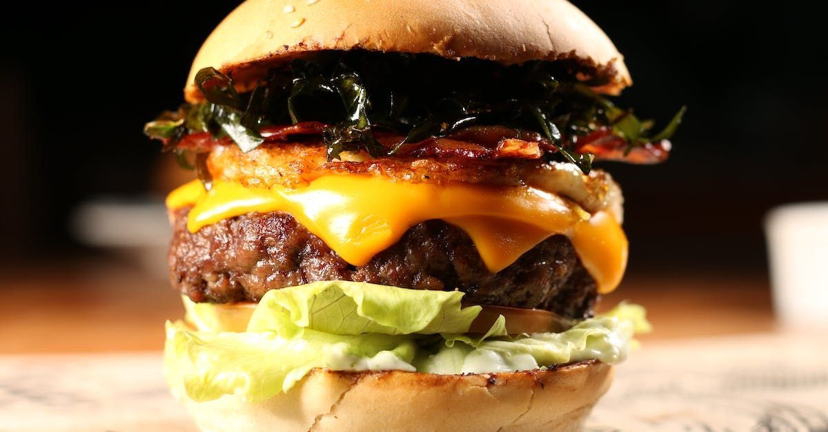 A close up of a hamburger on a bun on a table.