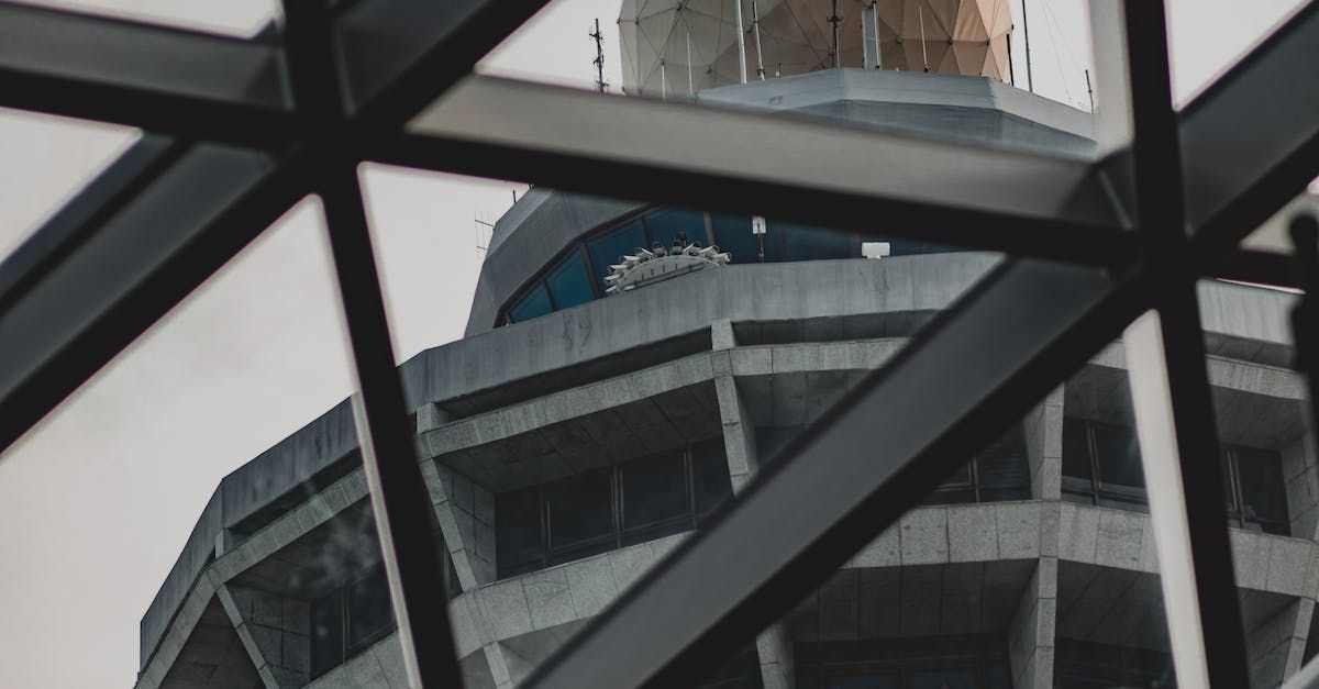 A view of a building under construction through a metal structure.