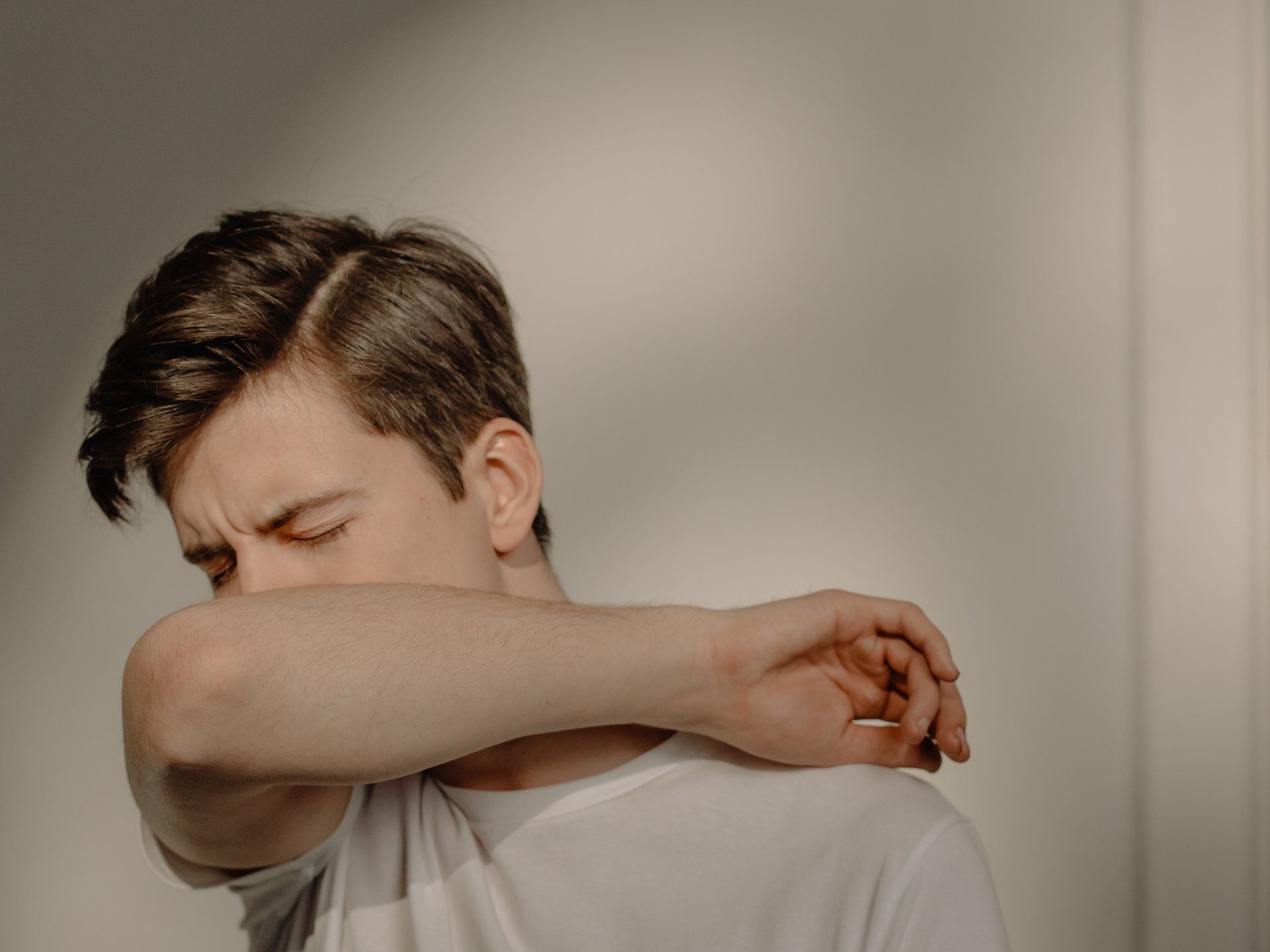 a man covering his nose using his elbow