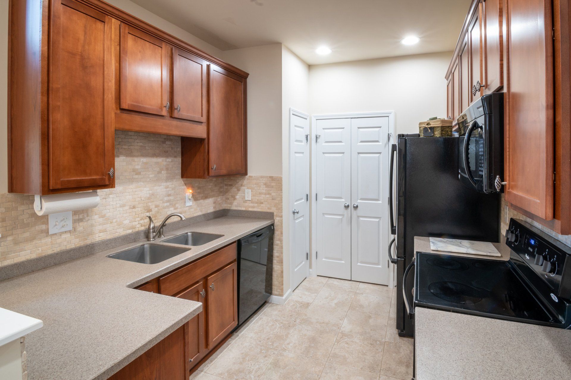 a kitchen with wooden cabinets , granite counter tops , a stove , refrigerator , dishwasher and microwave .