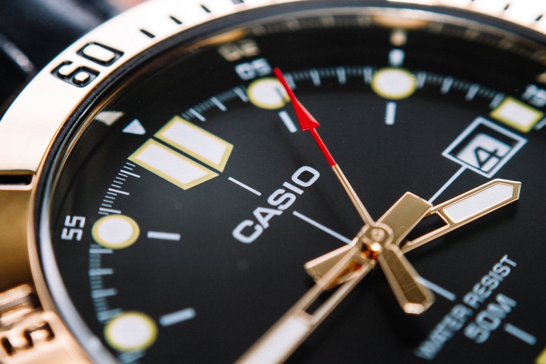 a close up of a black and gold casio watch