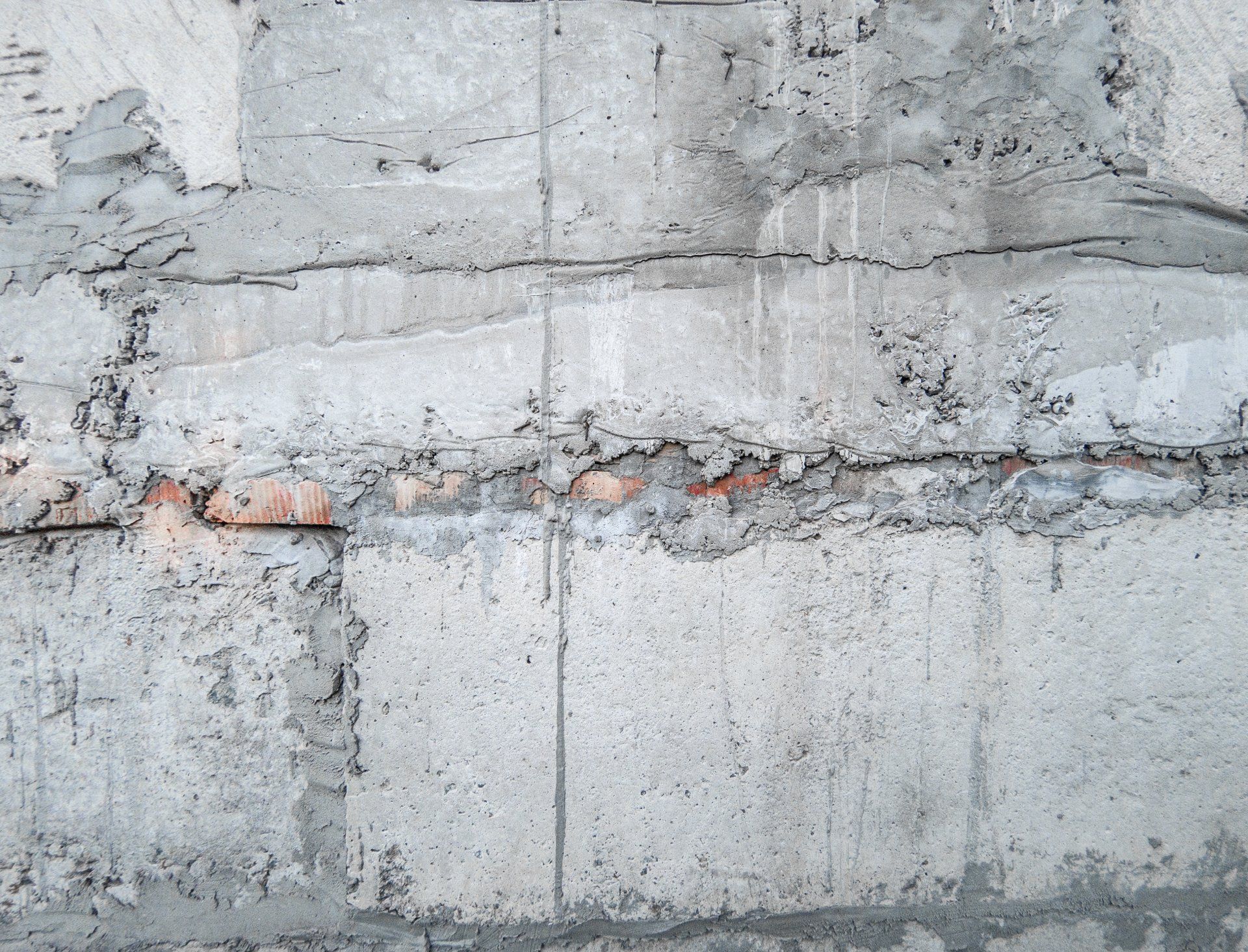 close-up view of the exterior of a concrete foundation, there are cracks