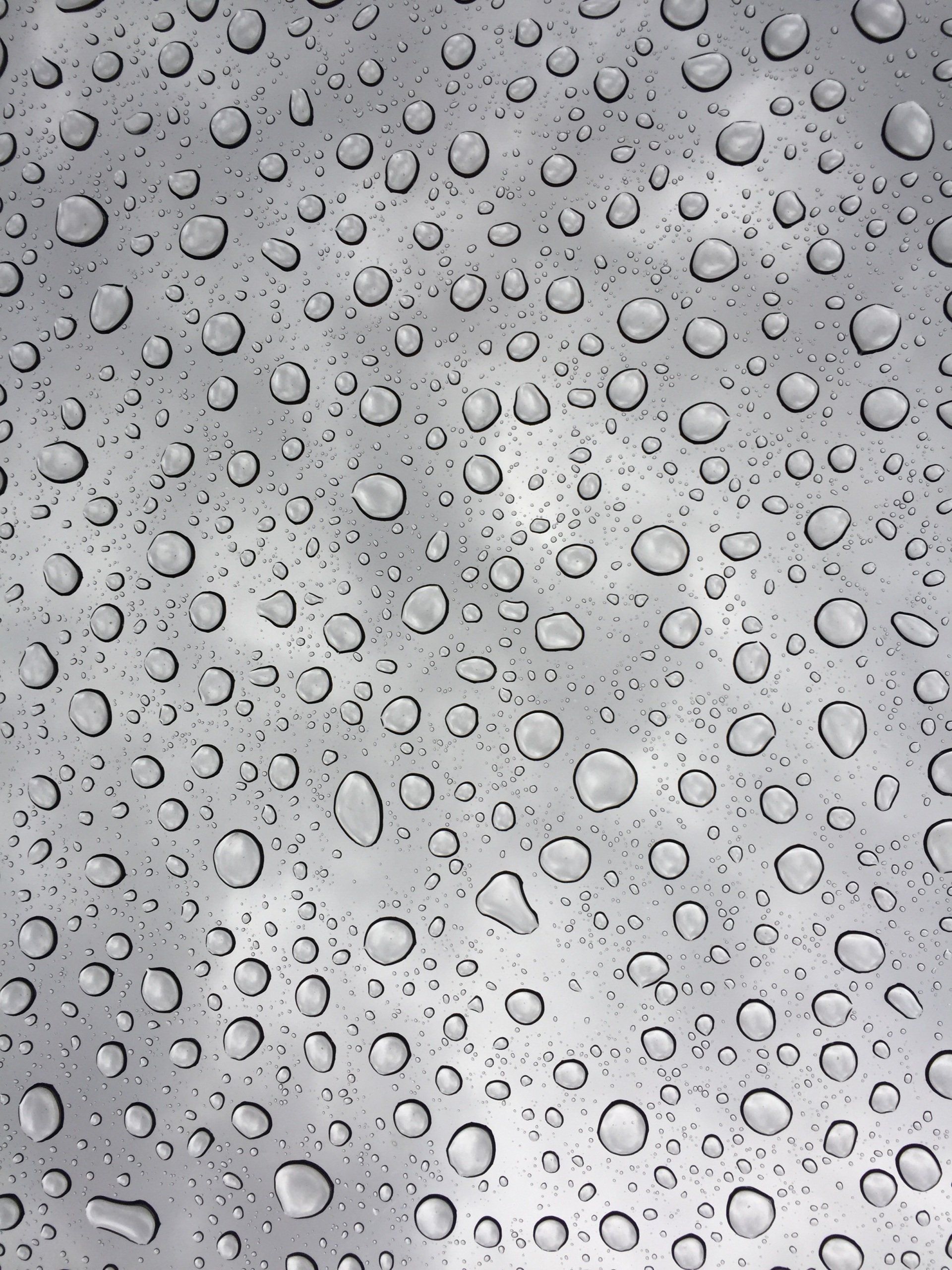 A bunch of water drops on a gray surface