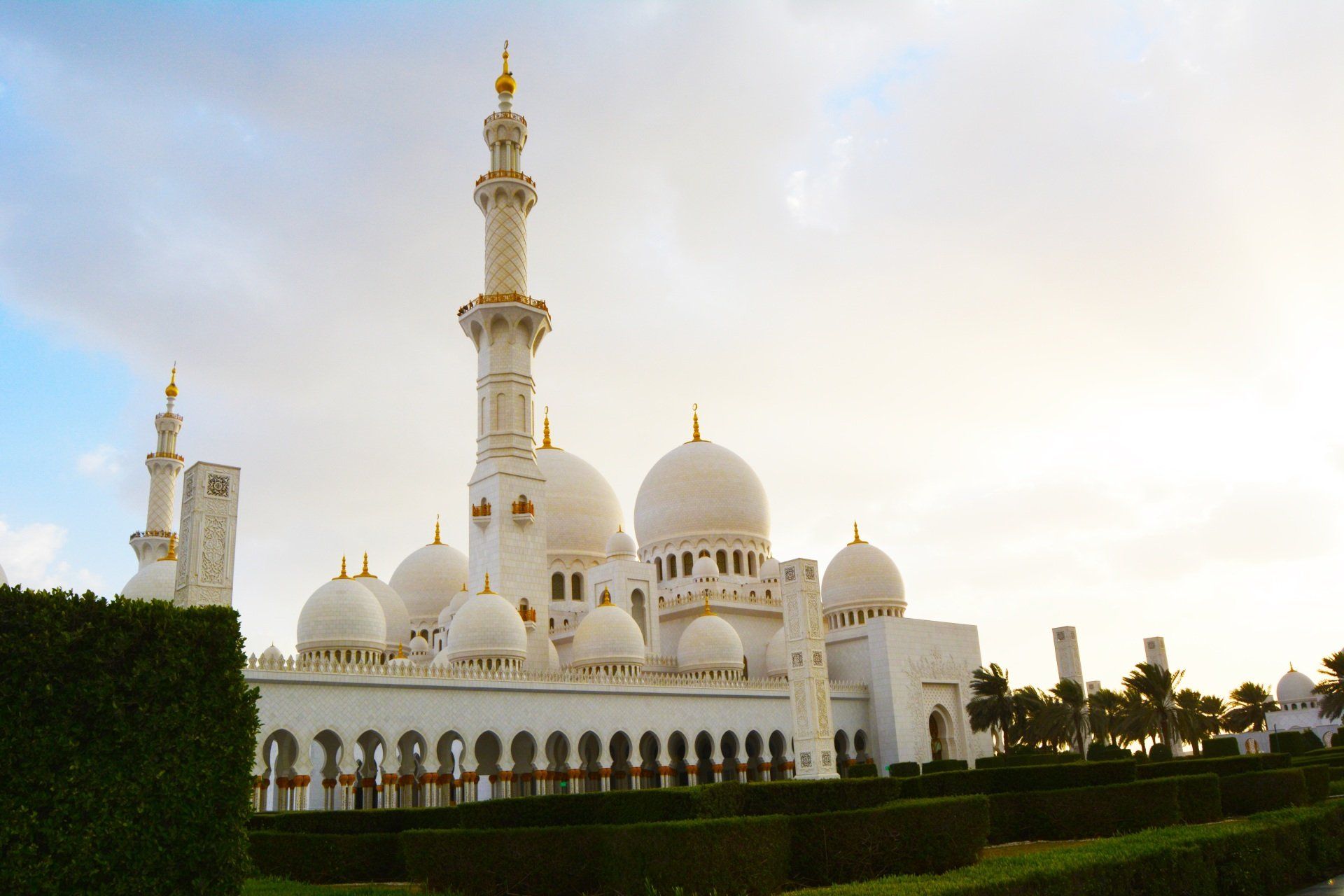 A large white mosque with a blue sky in the background.