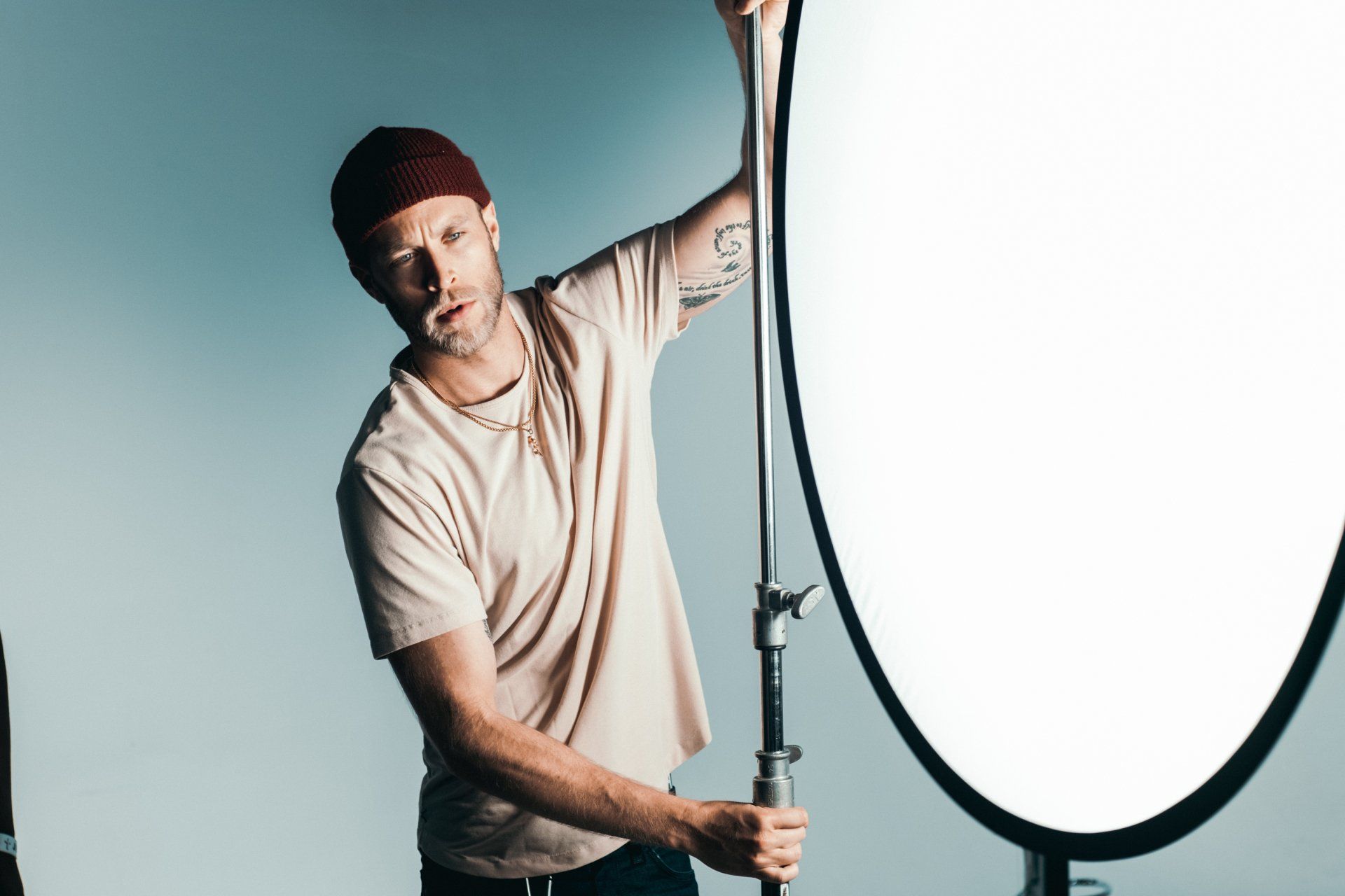 A man is standing in front of a white light.