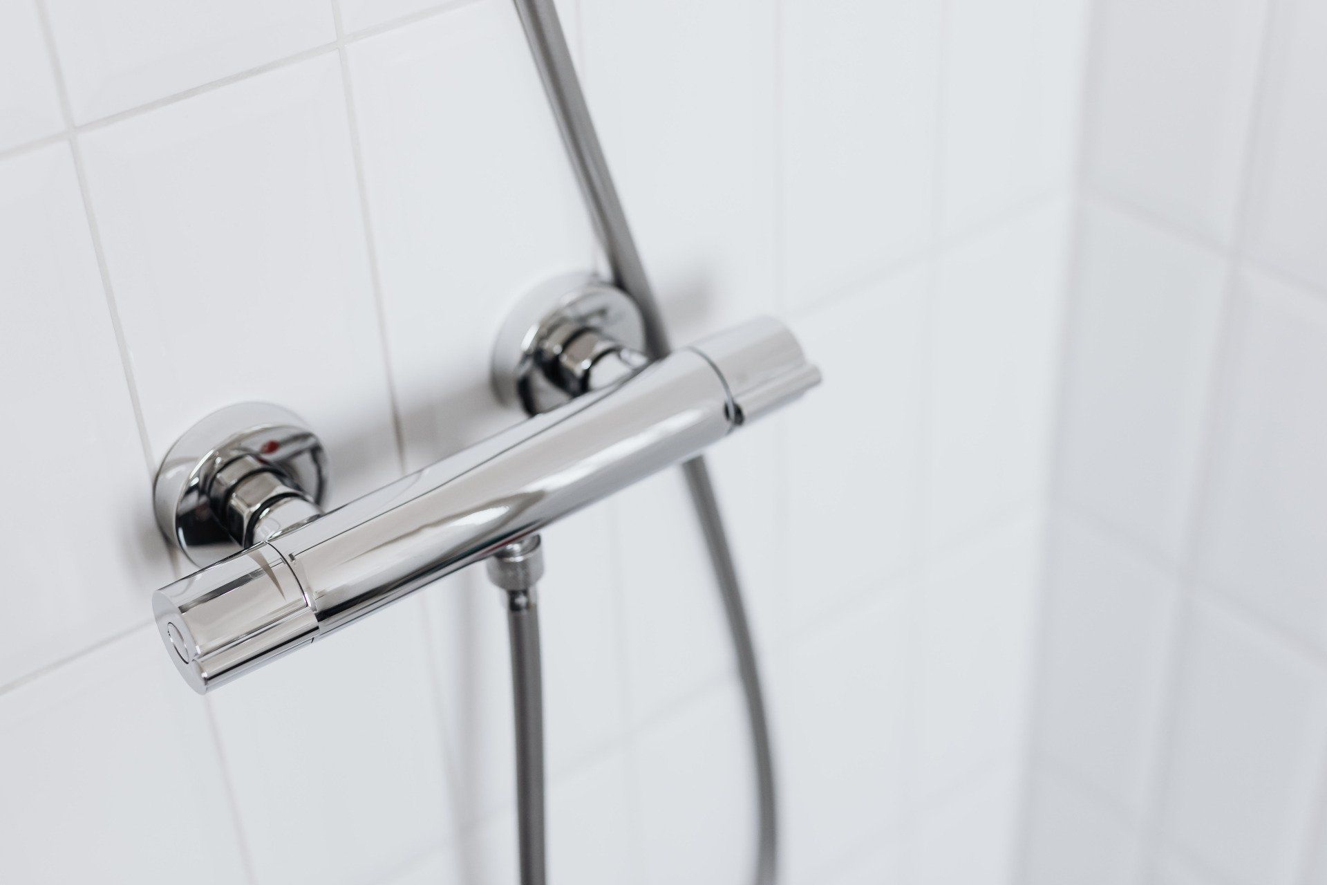A picture of a chrome shower mixer bar
