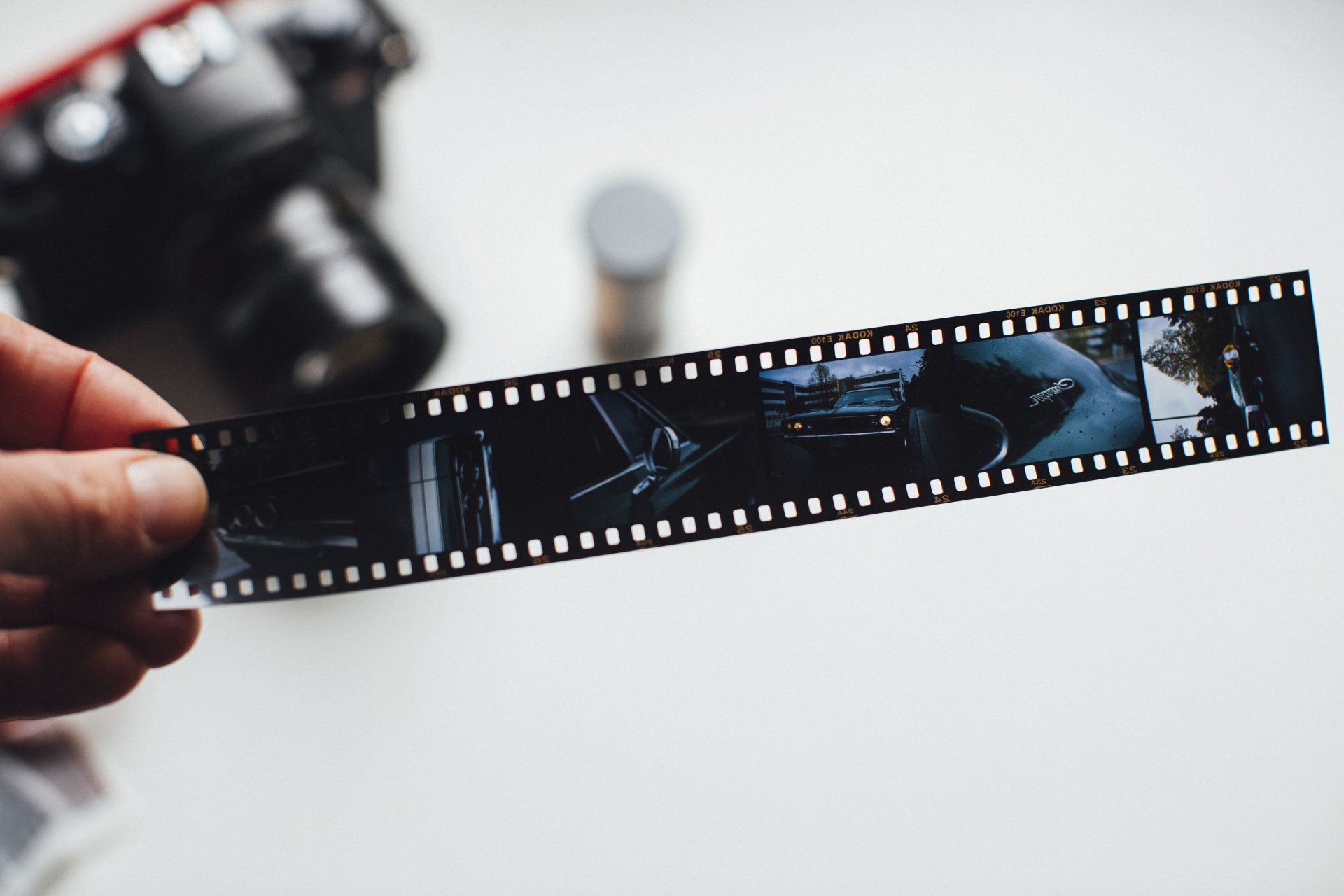 A person holding a film strip with a camera