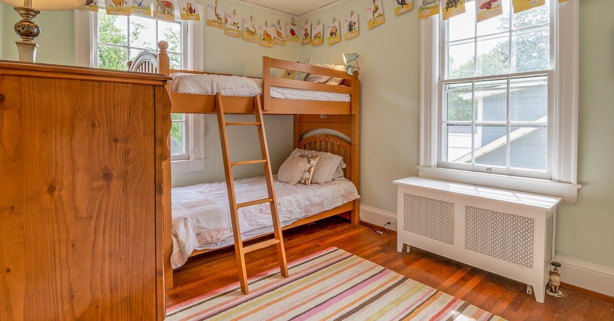 A bedroom with two bunk beds and a rug.