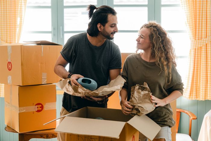 A man and a woman are moving into a new house.