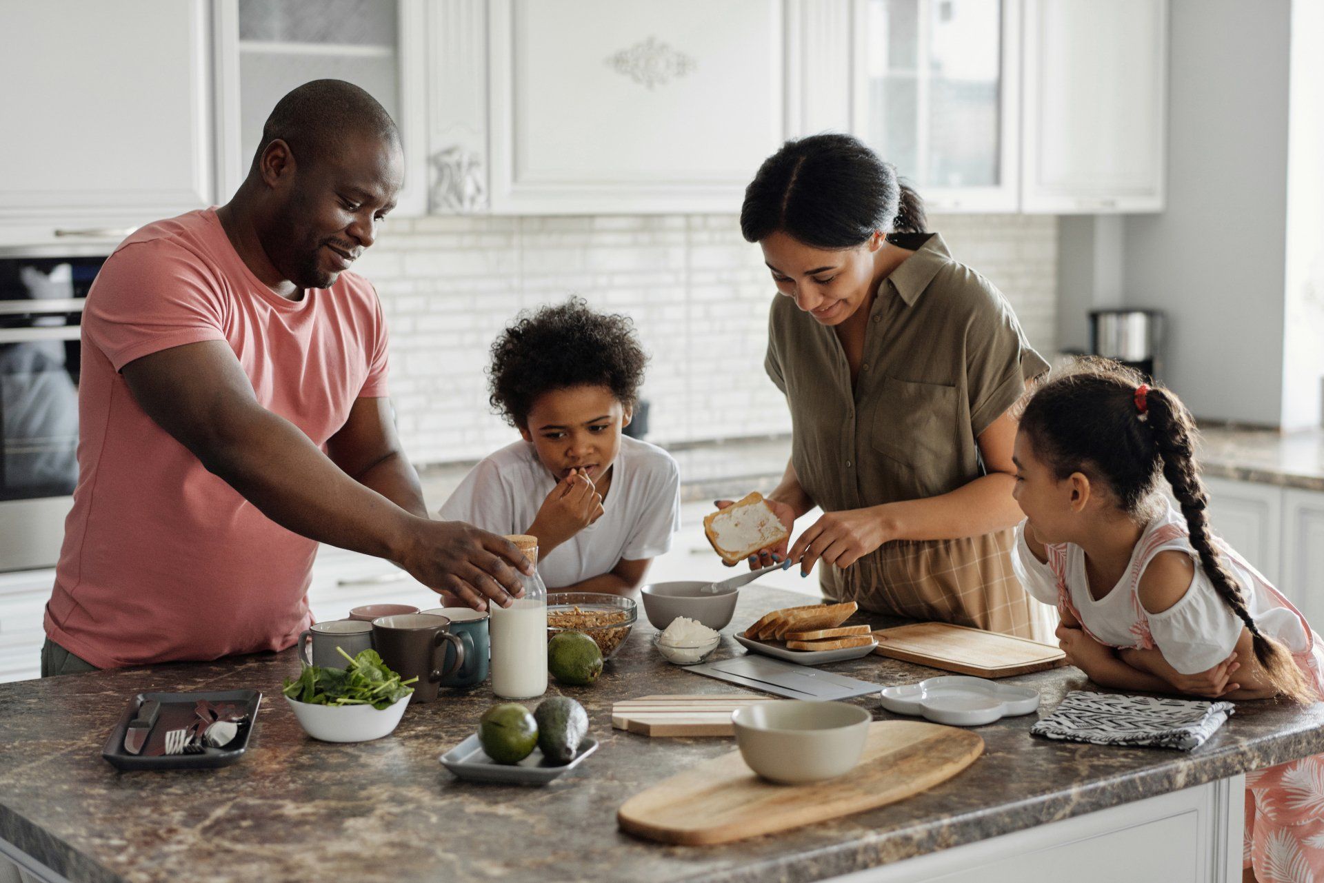 A family is preparing food together in a kitchen.
