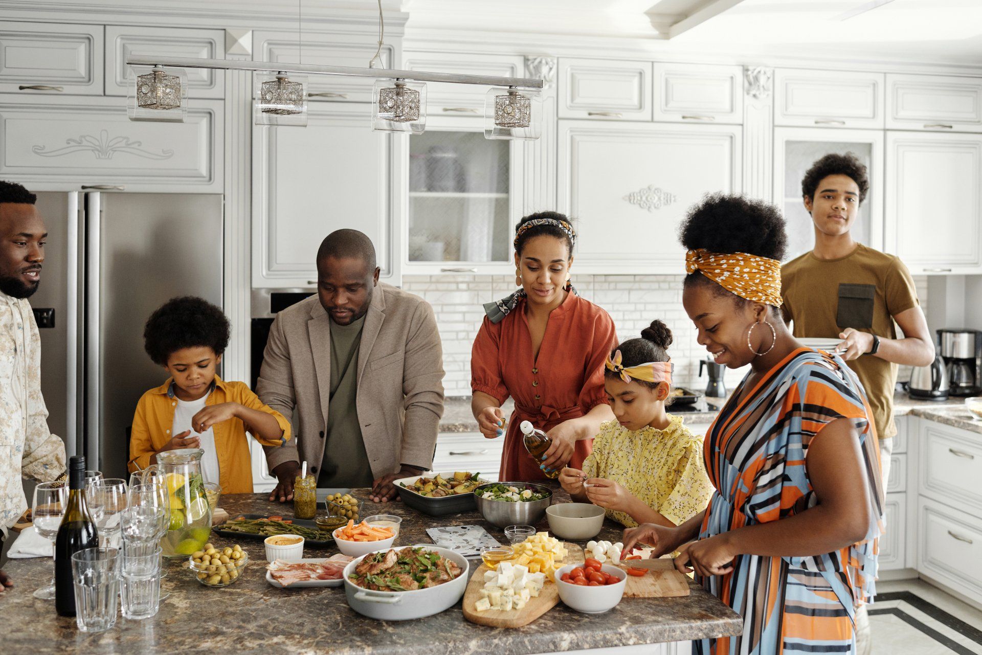 A family is preparing food together in a kitchen.
