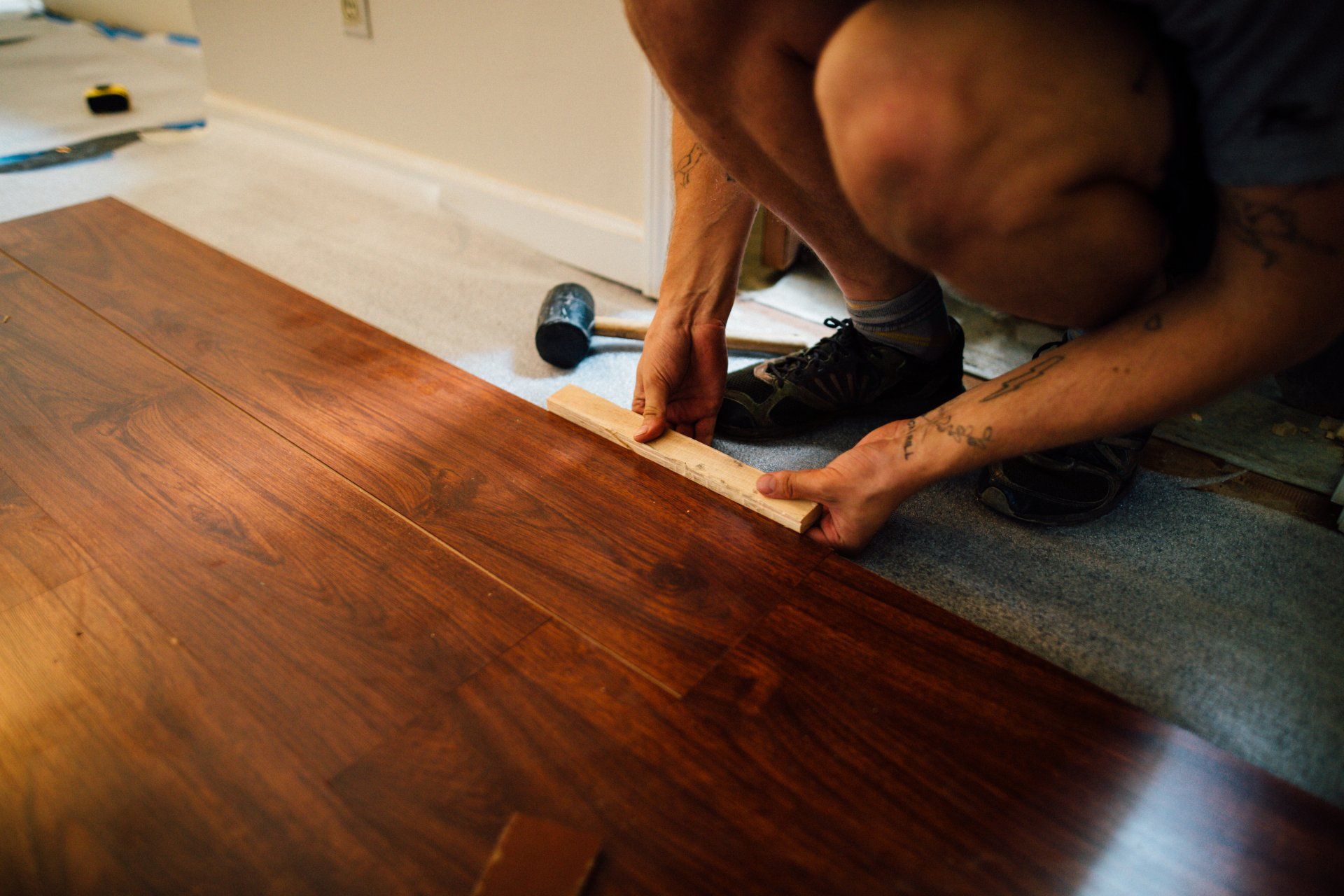 Installer actively installing hardwood planks