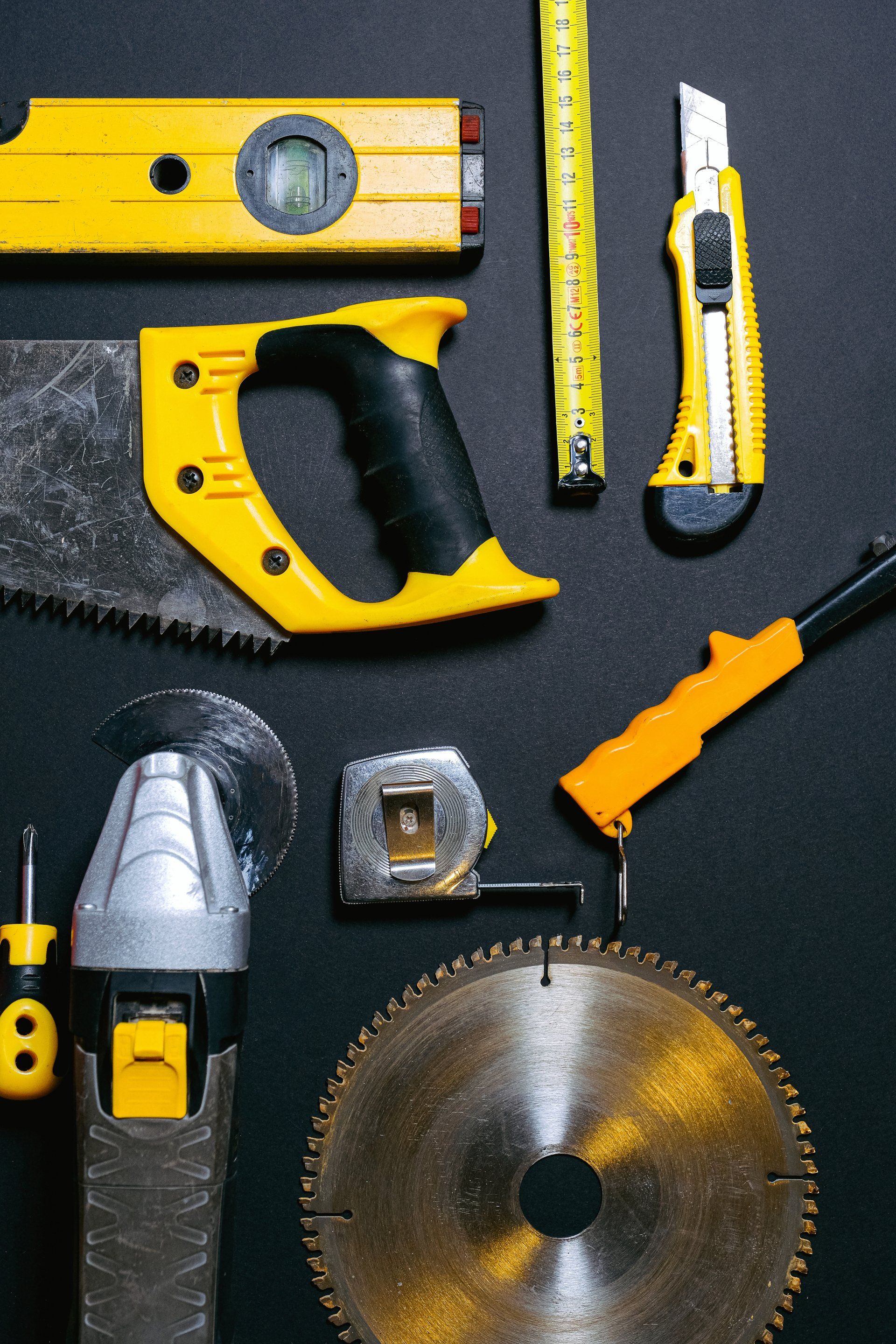 a circular saw and other tools are laid out on a black surface