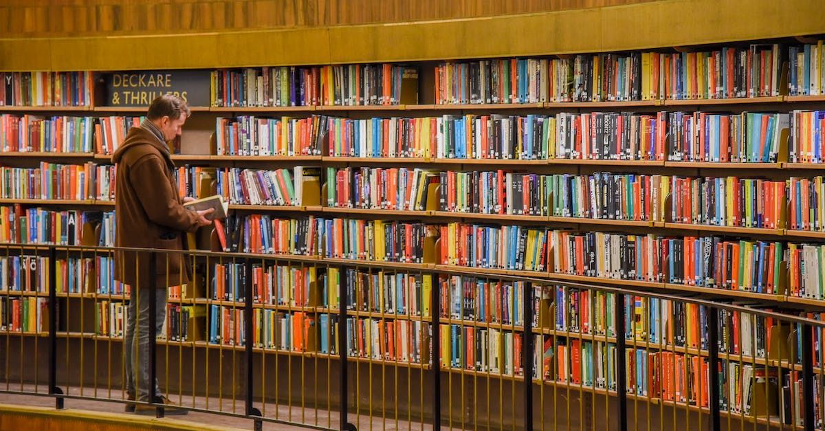 man searching for a book in a library