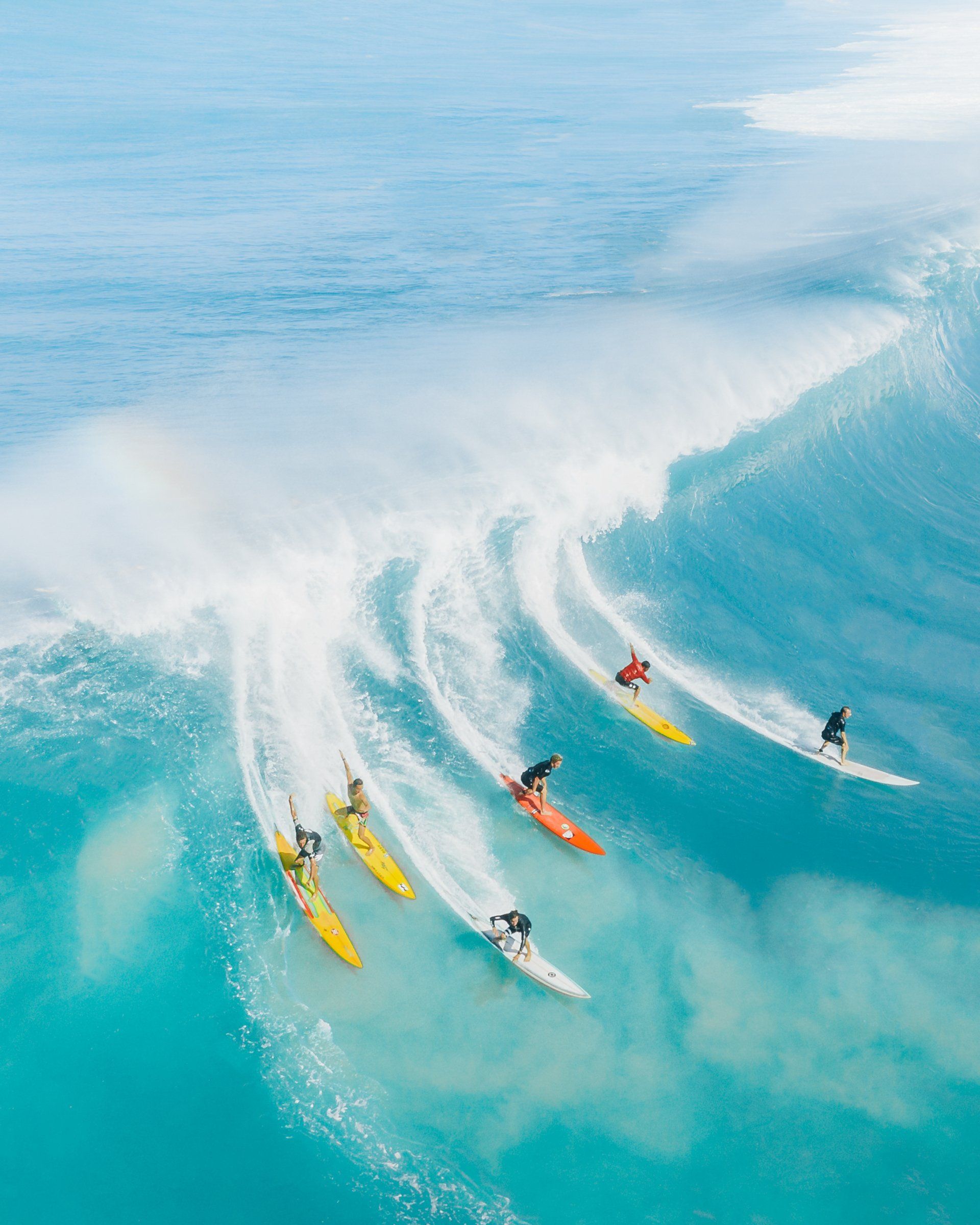 A group of surfers are riding a wave in the ocean.