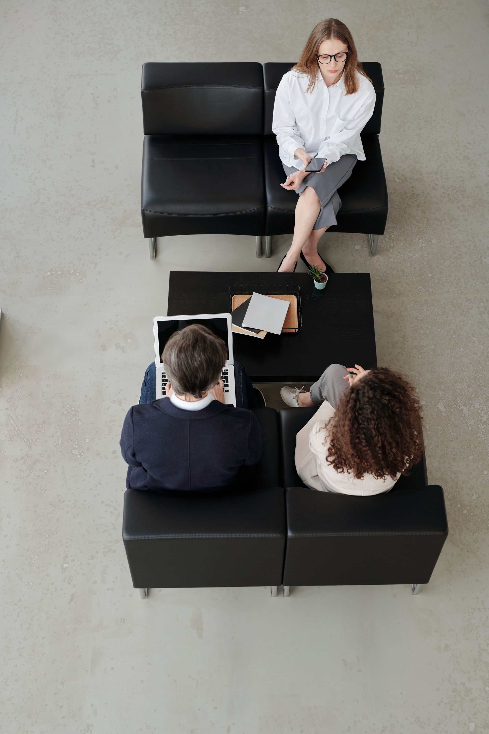 Um grupo de pessoas está sentado em cadeiras em uma sala de espera.