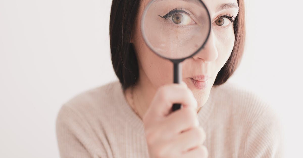 woman holding a magnifying glass to her eye