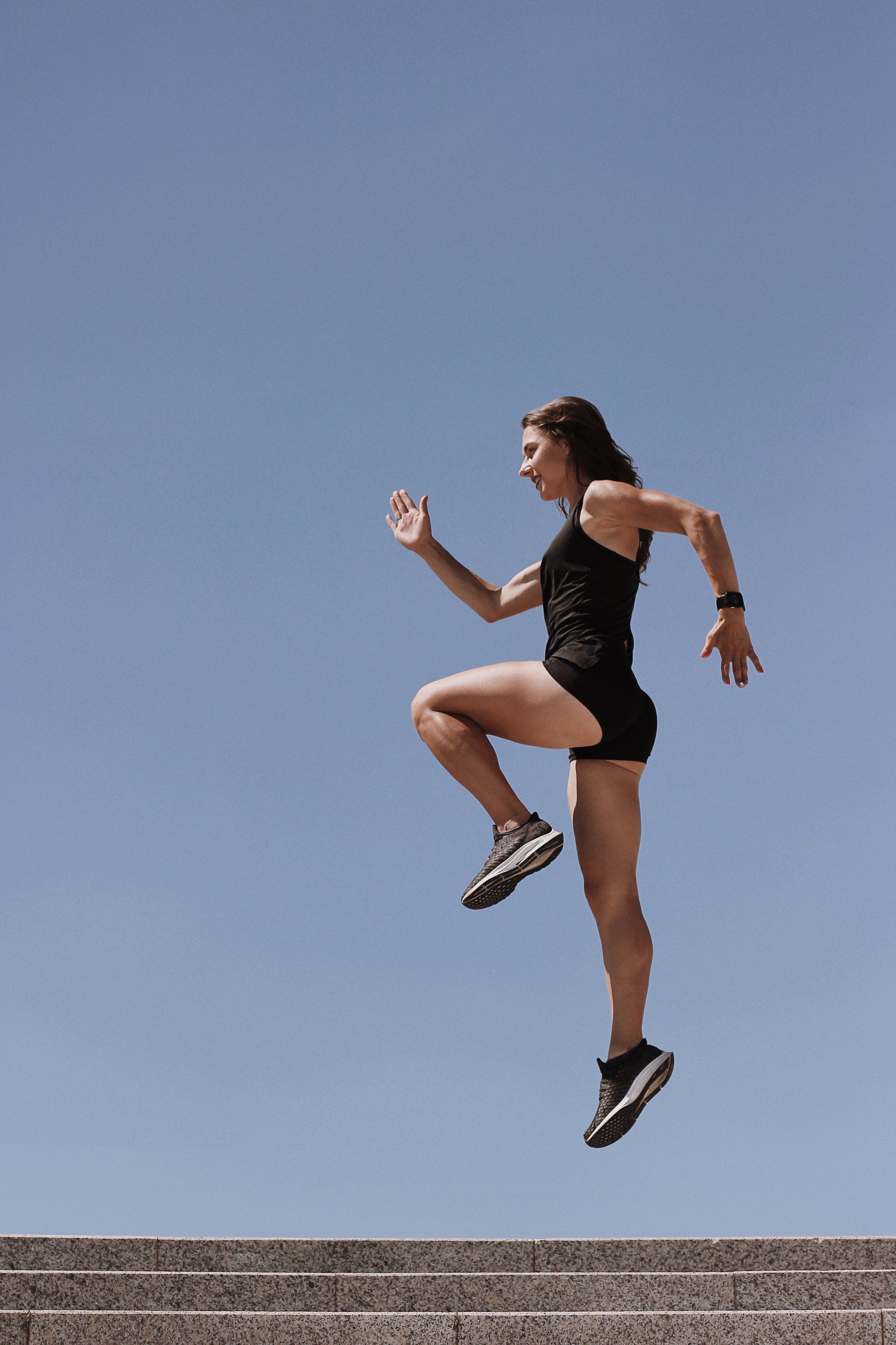 a woman is jumping in the air on a set of stairs.