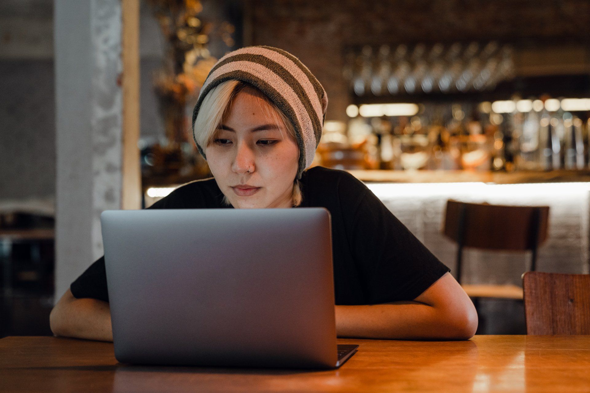 A woman is sitting at a table using a laptop computer.