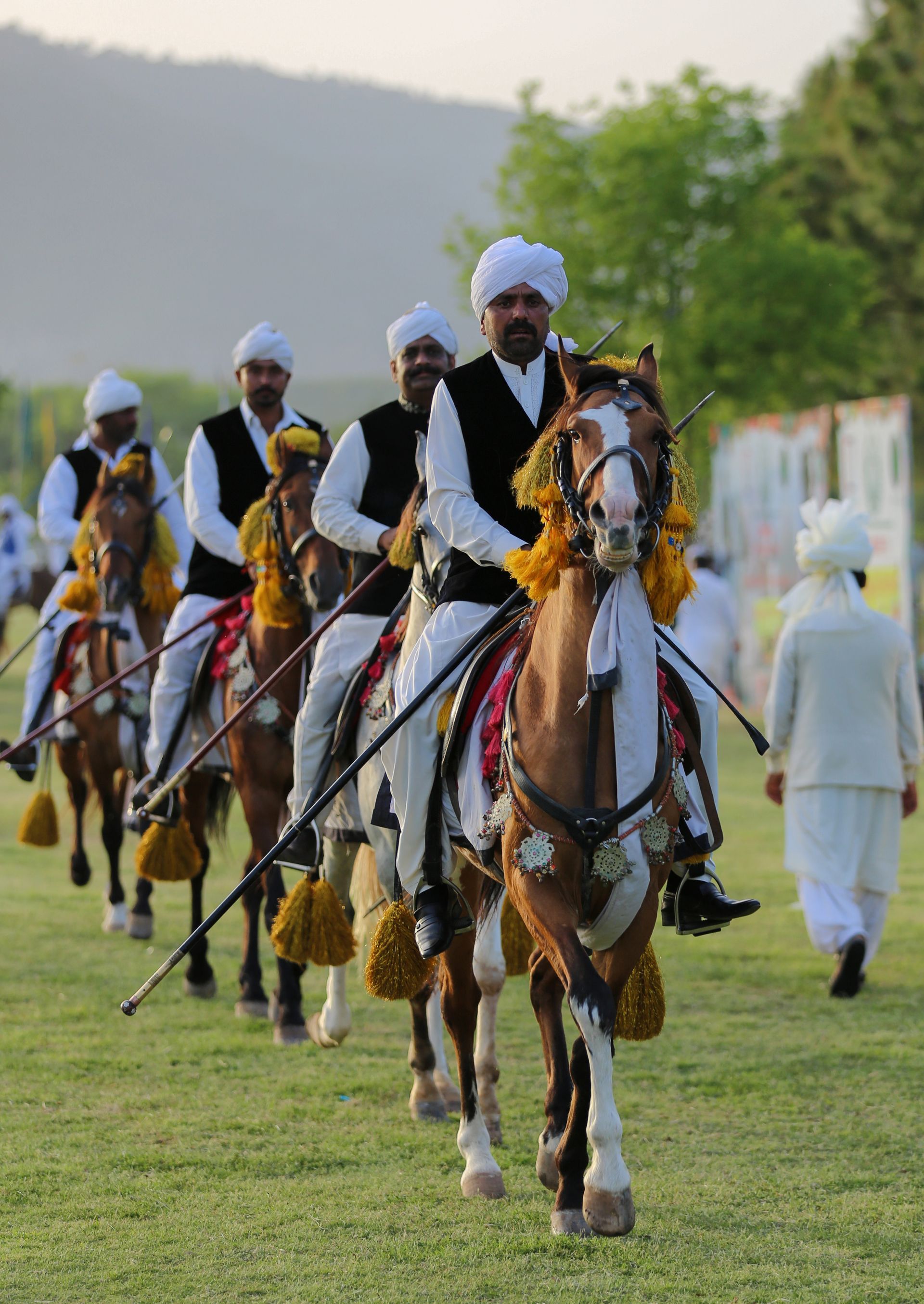 A group of men are riding horses in a field.