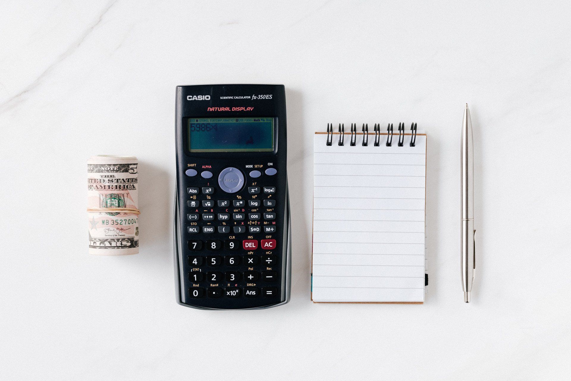 a calculator, pen, note, and paper bill