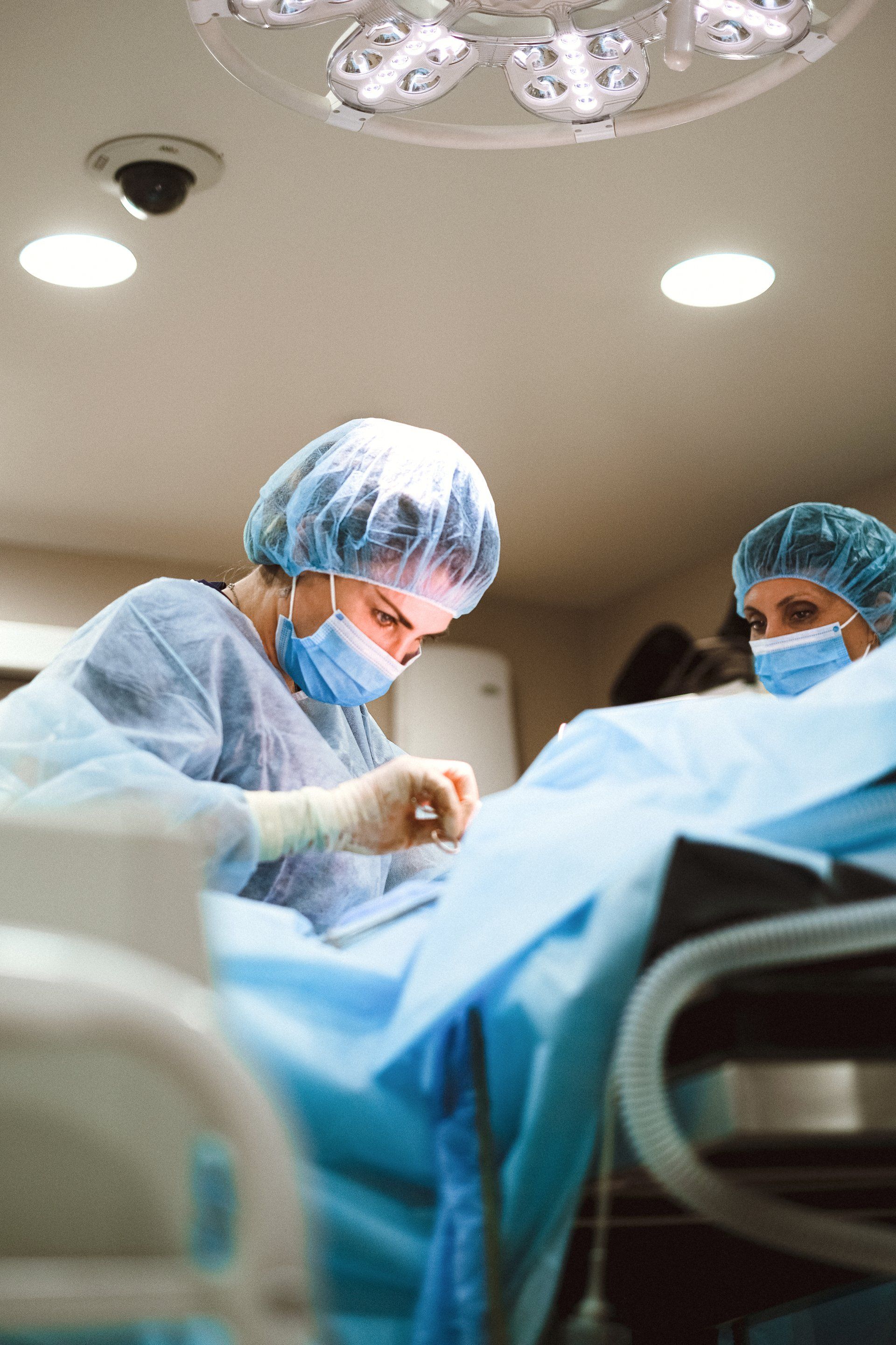 Two surgeons are operating on a patient in an operating room.