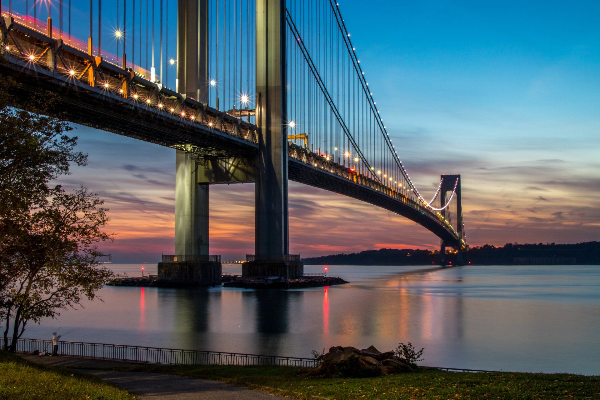 A bridge over a body of water at sunset.