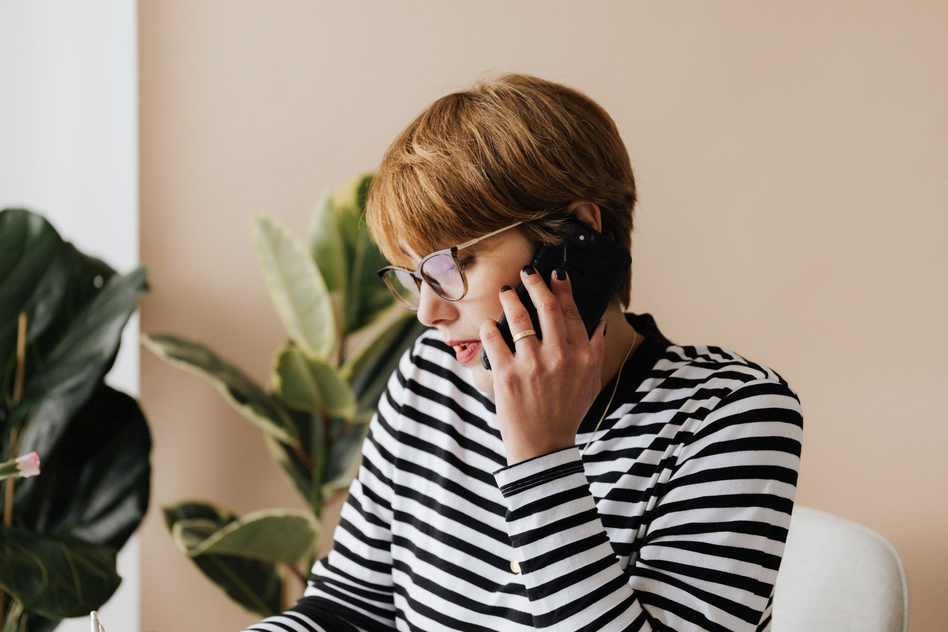 a woman wearing glasses is talking on a cell phone