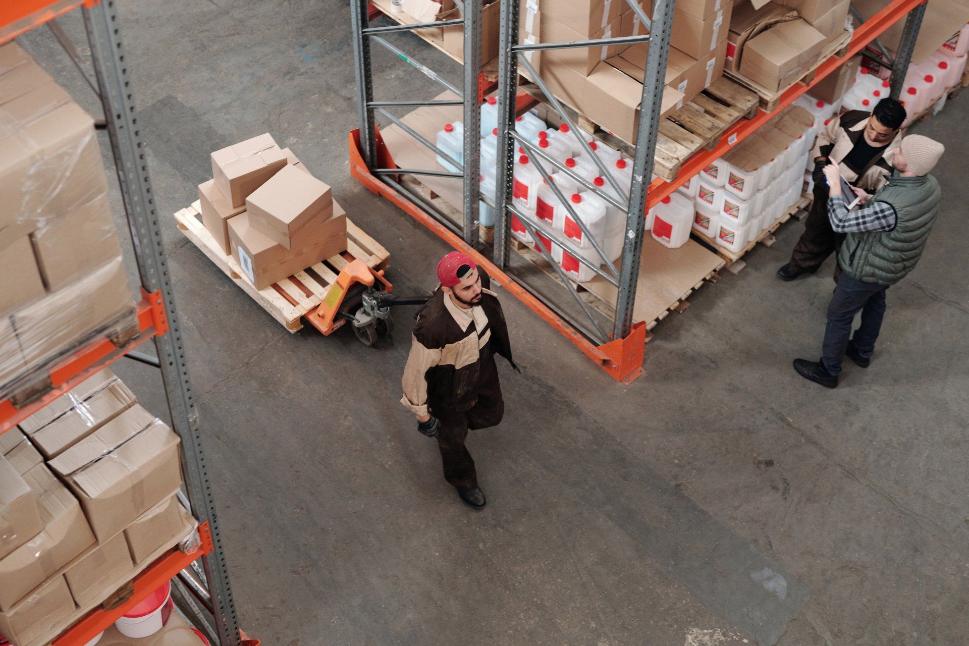 This is an image of a warehouse worker pulling boxes through a warehouse during a physical inventory count.