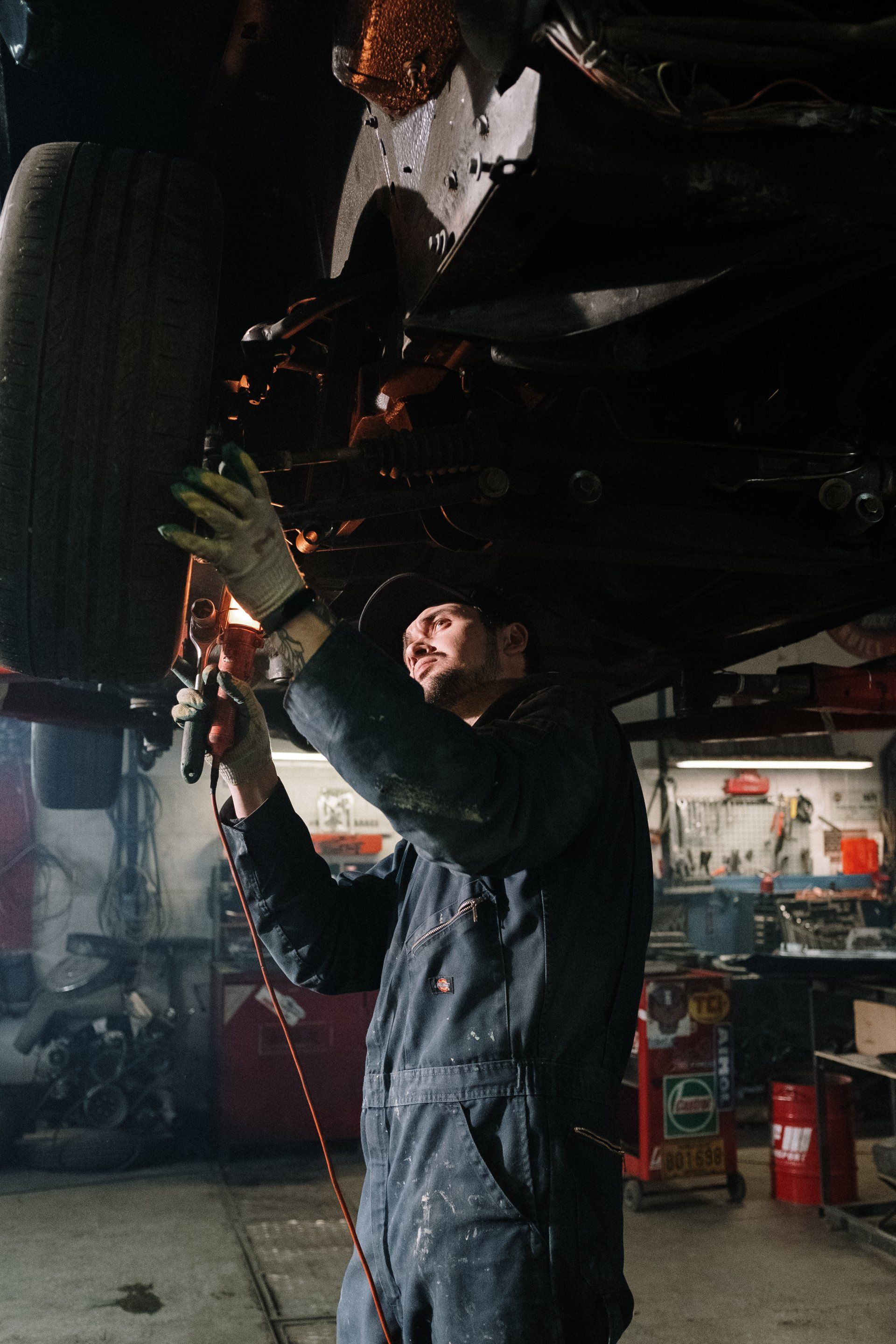 A man is working under a car in a garage | PNW Automotive