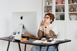 A laptop computer is sitting on a wooden table next to a cup of coffee.