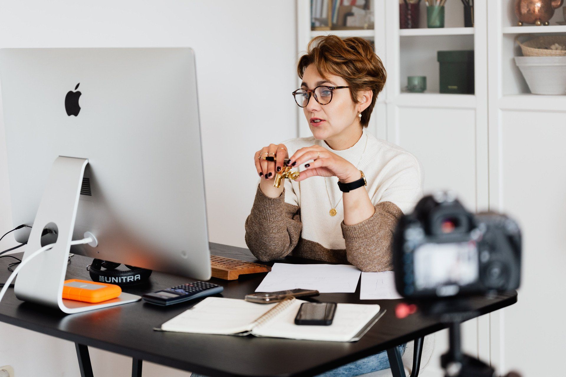 una mujer está sentada en un escritorio frente a una computadora.