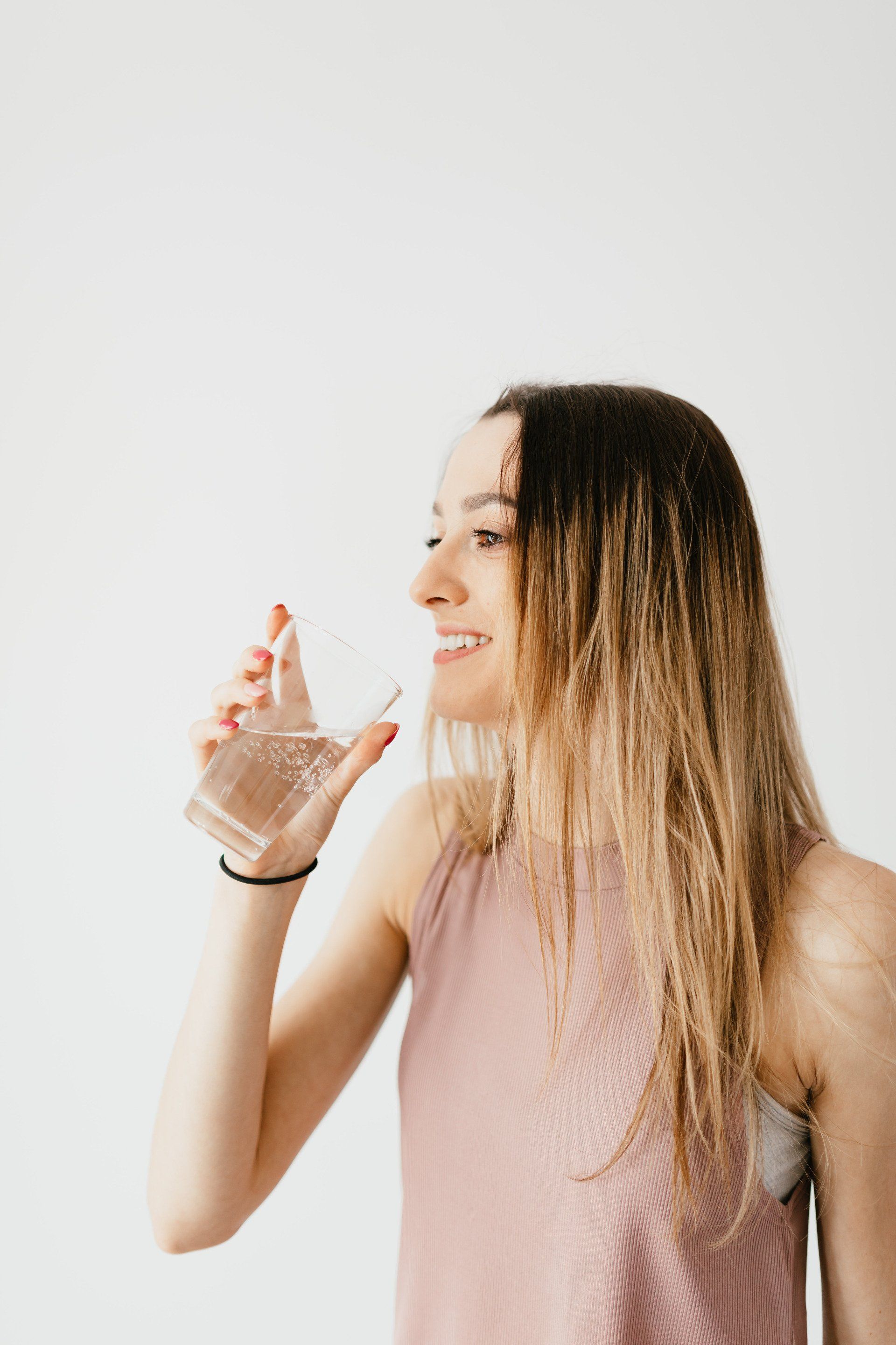 A woman is drinking a glass of water.