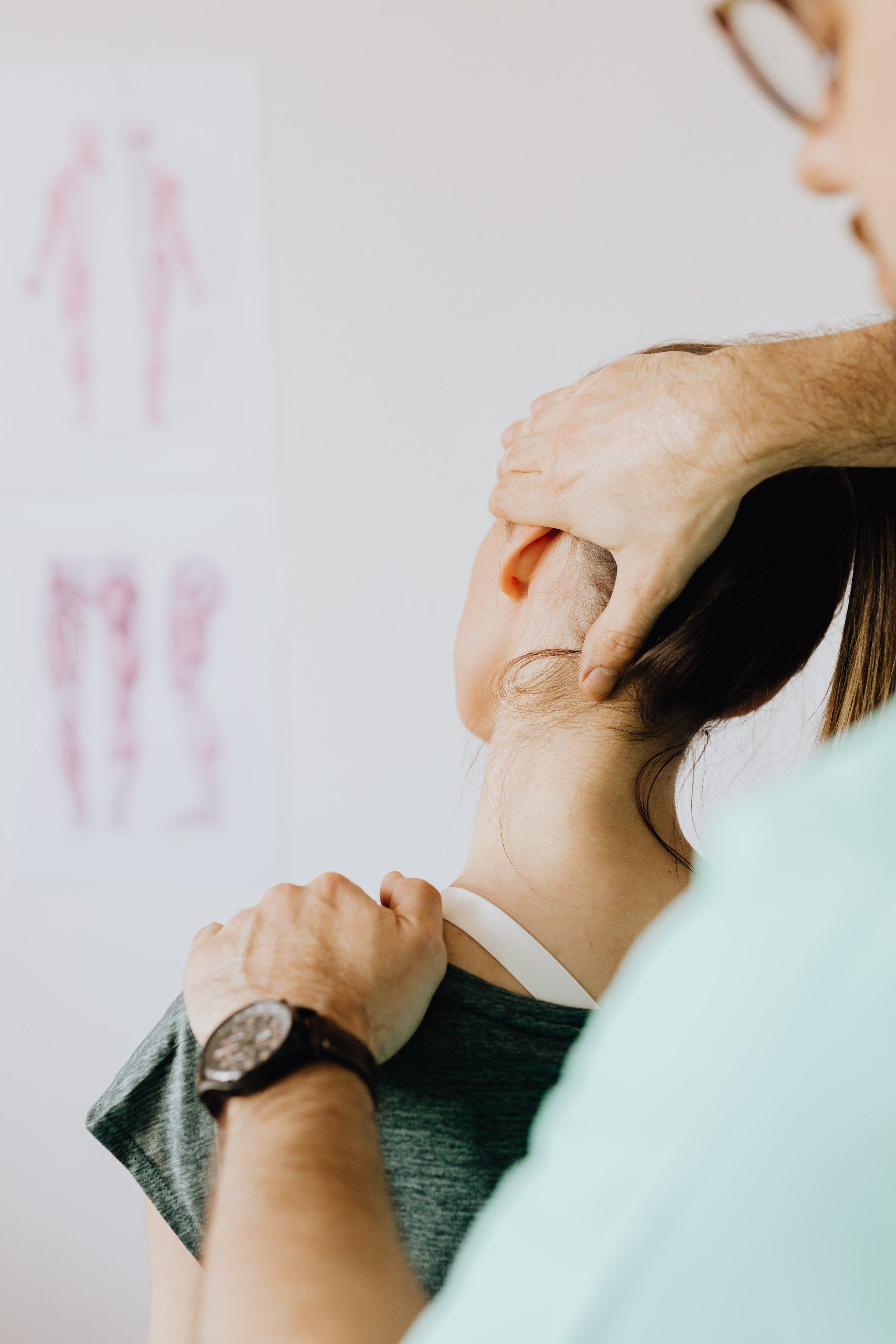 A man is giving a woman a massage on her neck.