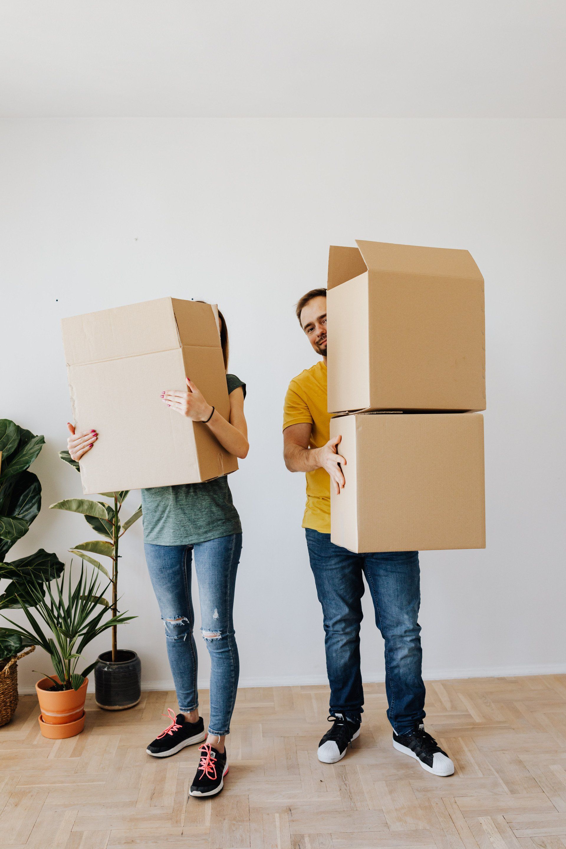 Couple carrying boxes with organized foil balloons