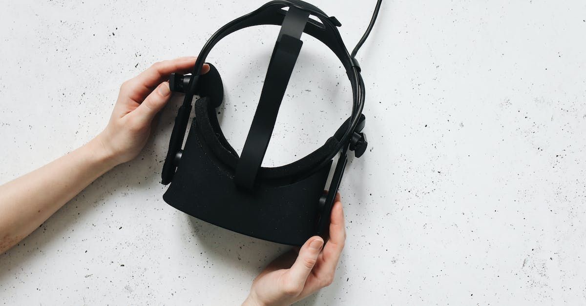 Uma pessoa está segurando um headset de realidade virtual nas mãos.