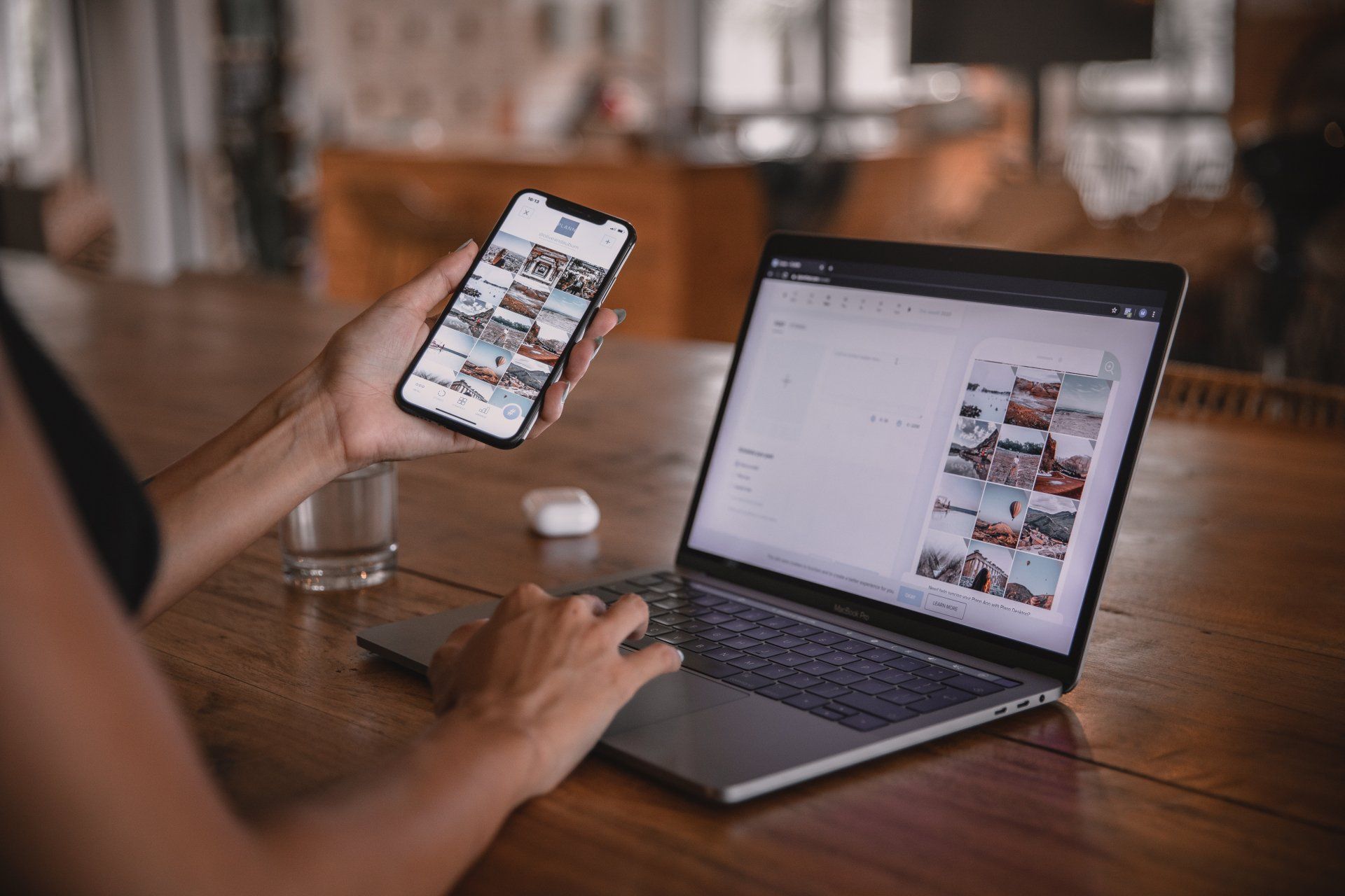 a person is holding a cell phone in front of a laptop computer 