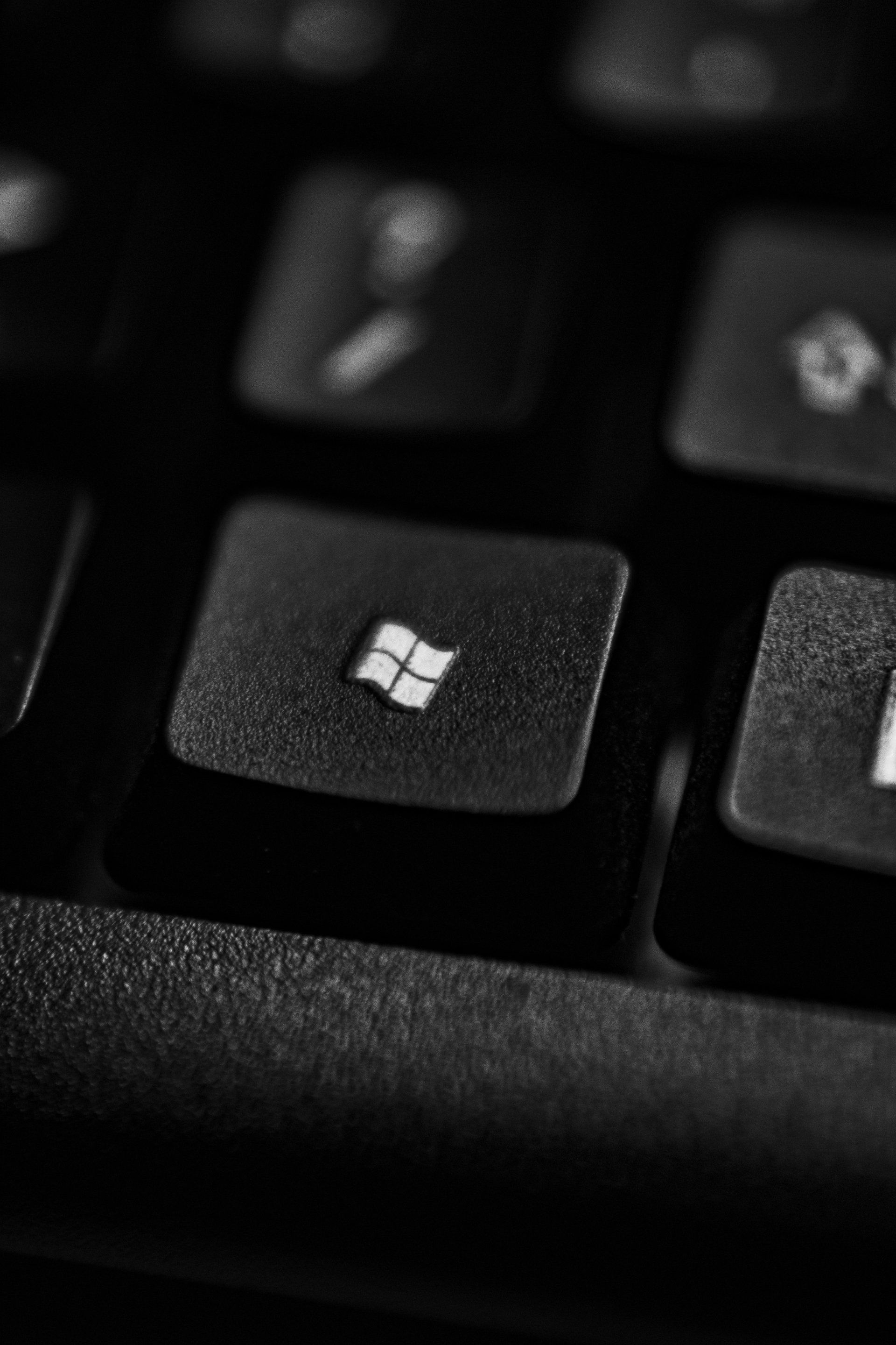 a close up of a black keyboard with a windows key