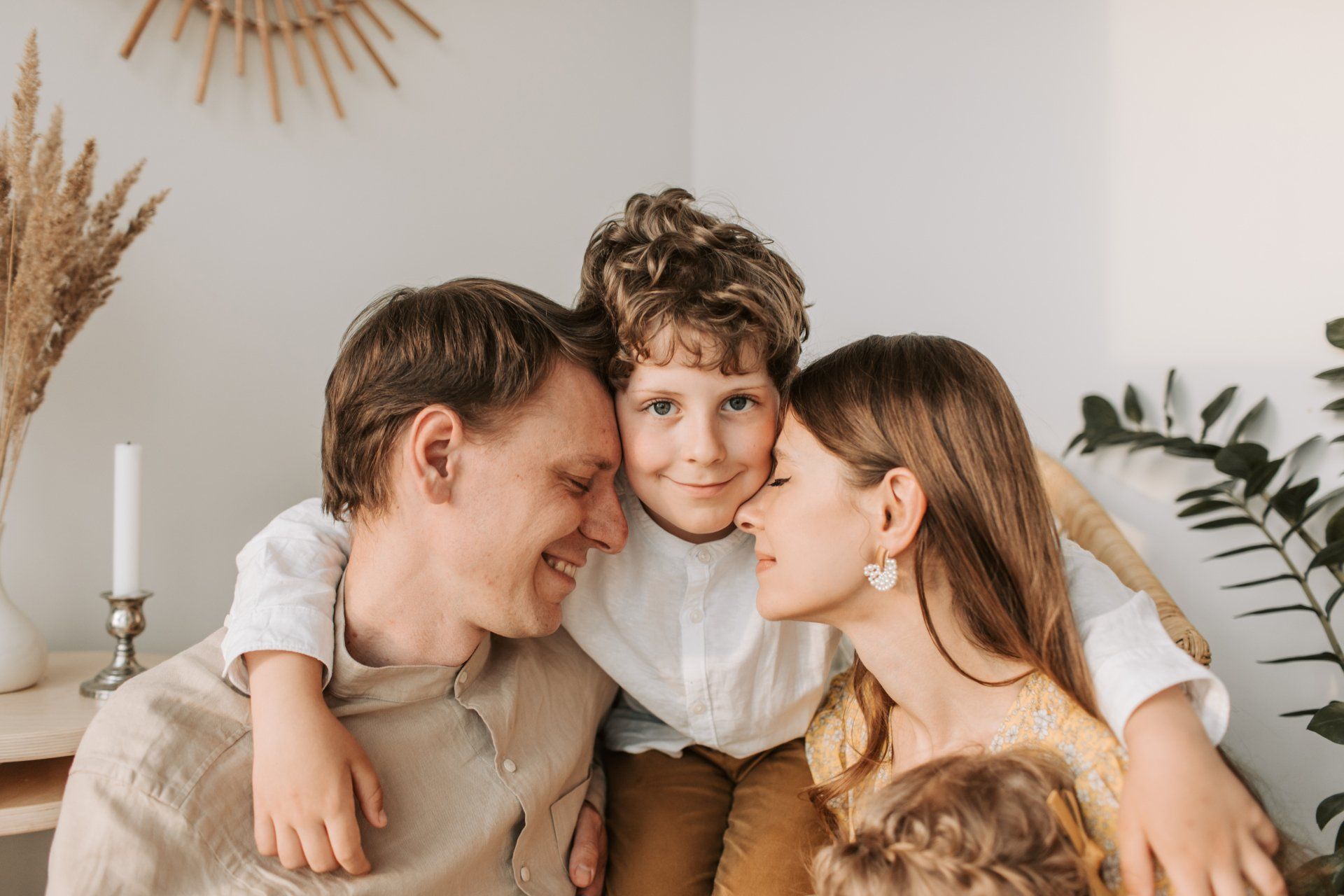 A family is posing for a picture together while sitting on a couch.