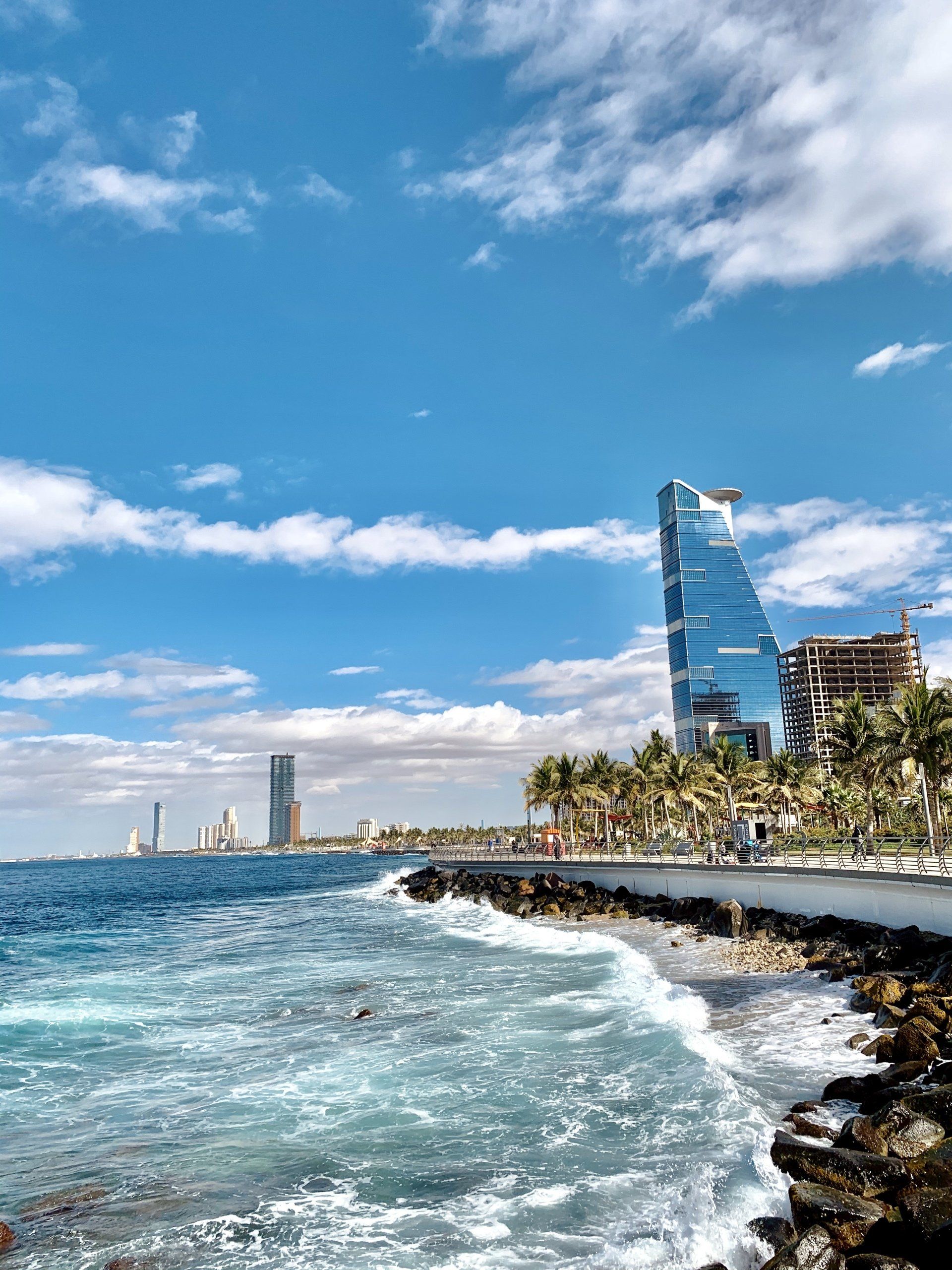 A view of the ocean with a tall building in the background