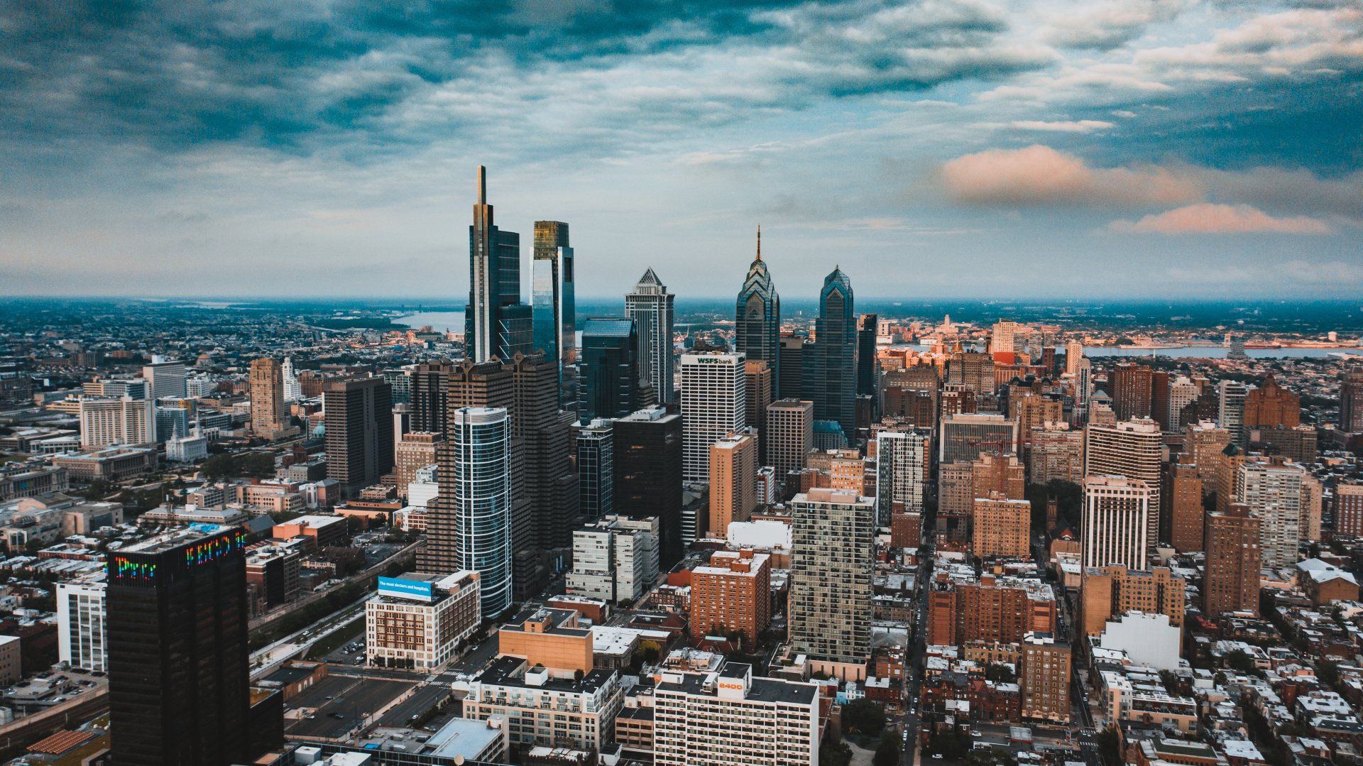 An aerial view of a Philadelphia city skyline with lots of buildings and a cloudy sky.